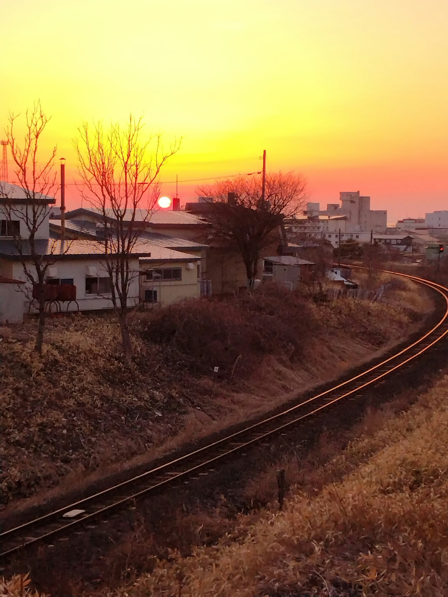 Scena rurale con tramonto e binari ferroviari