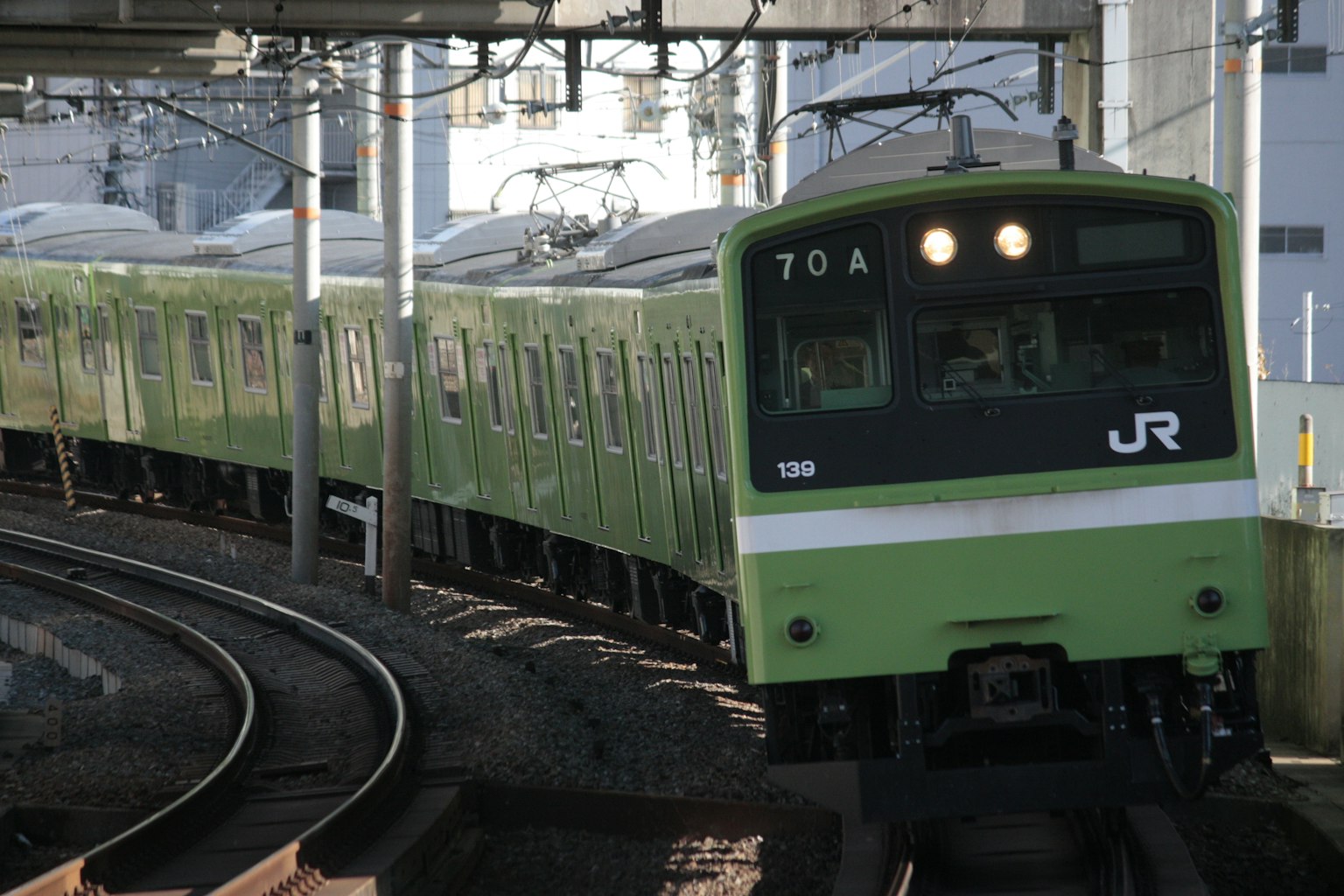 Kereta JR hijau berbelok di rel
