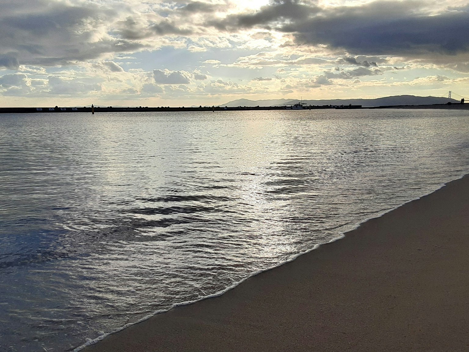 平静的海面与多云的天空和温和的波浪