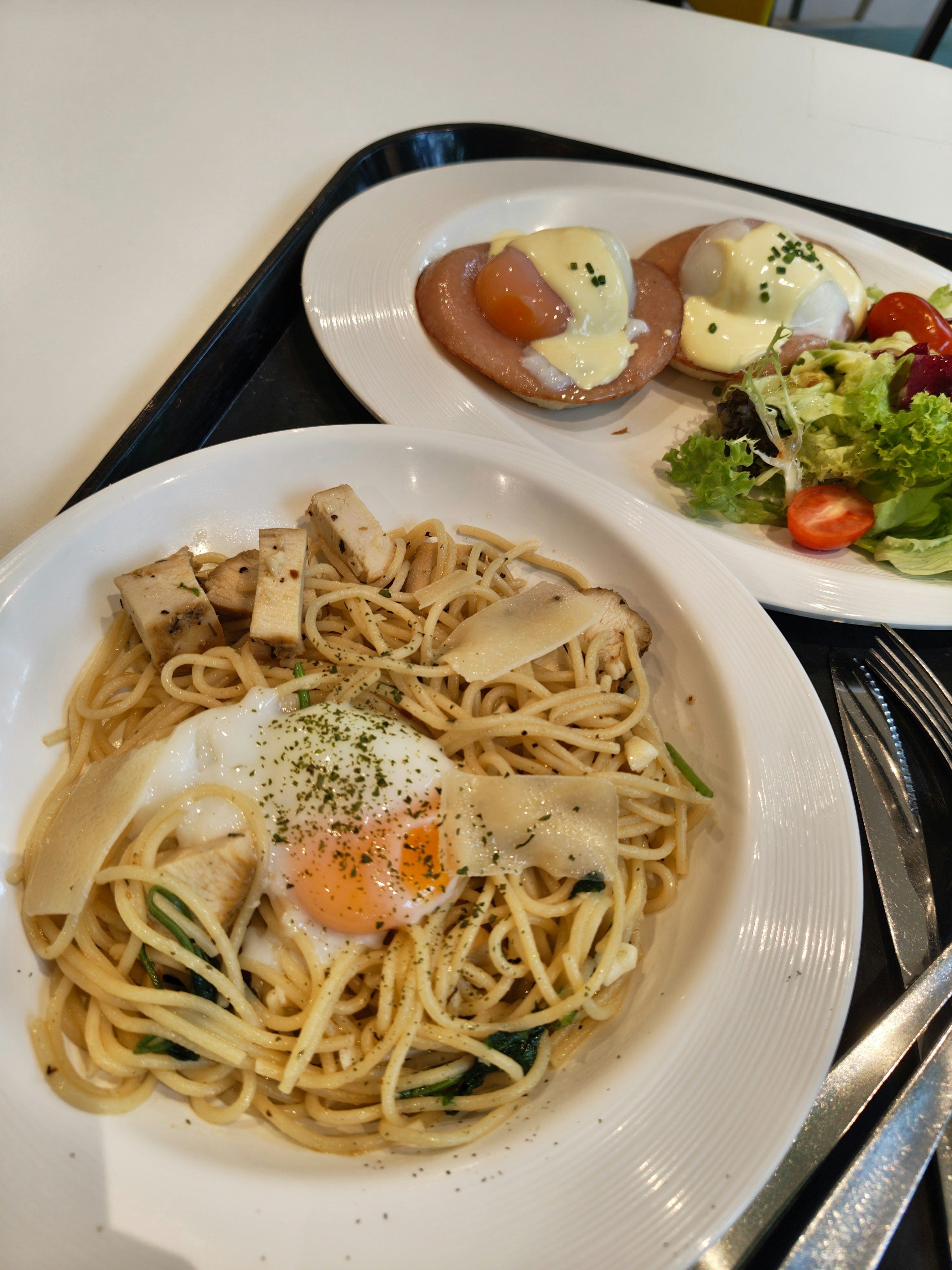 パスタとサラダ、パンのプレートが並ぶランチ