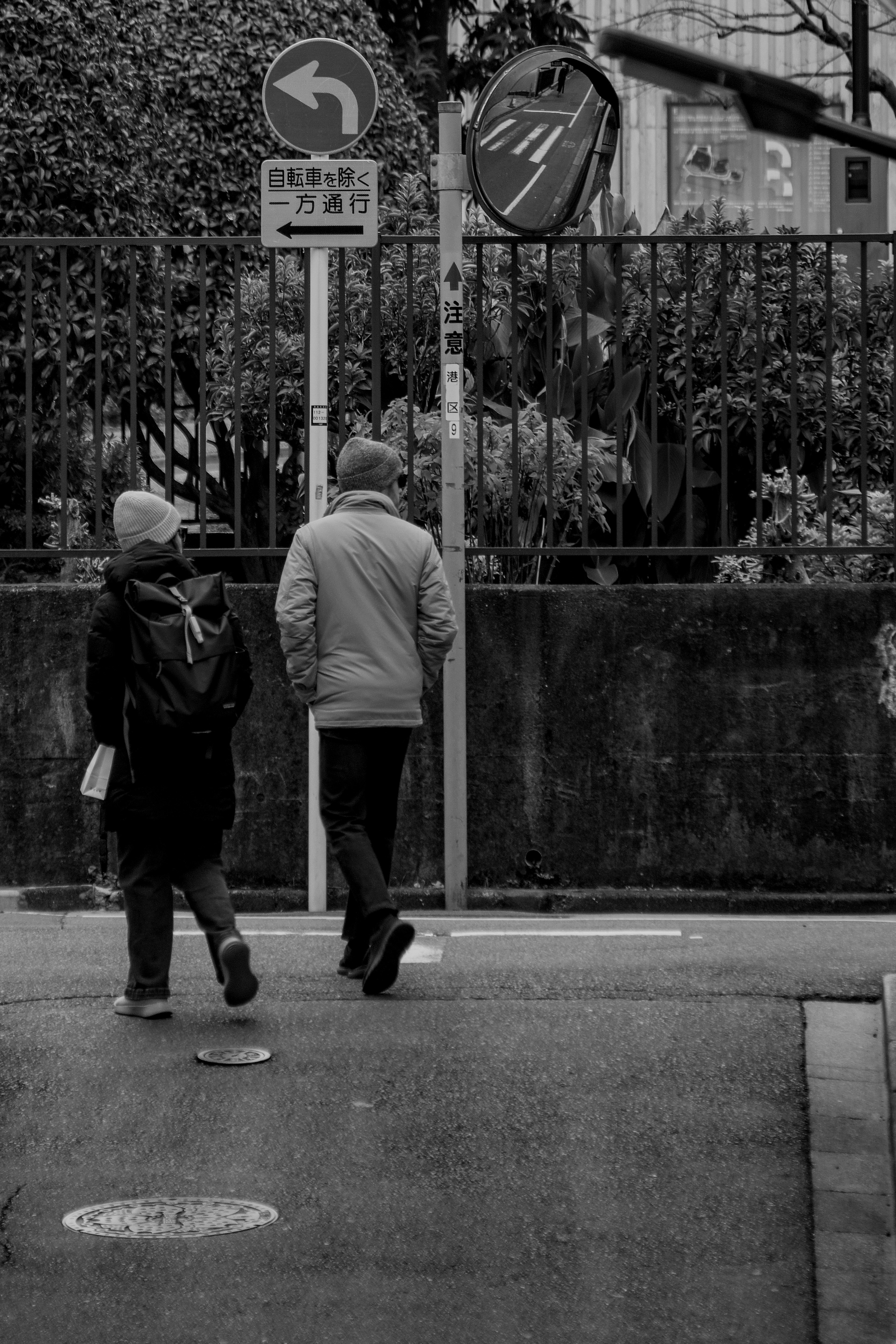 urban sidewalk with people walking under streetlights