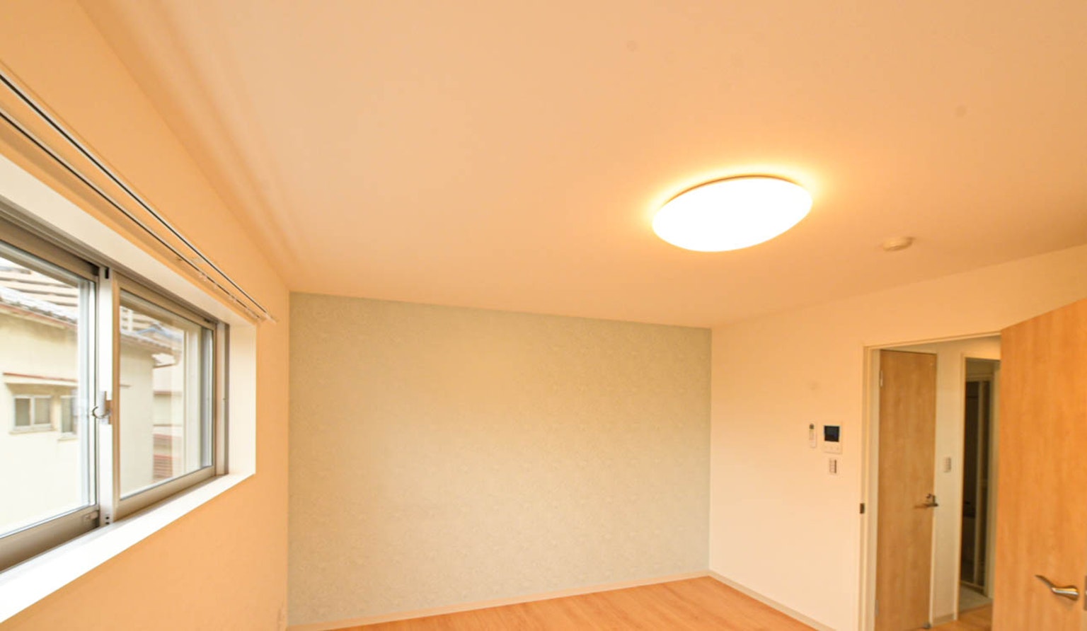 Heller Raum mit einem großen Fenster und einer einfachen Tür