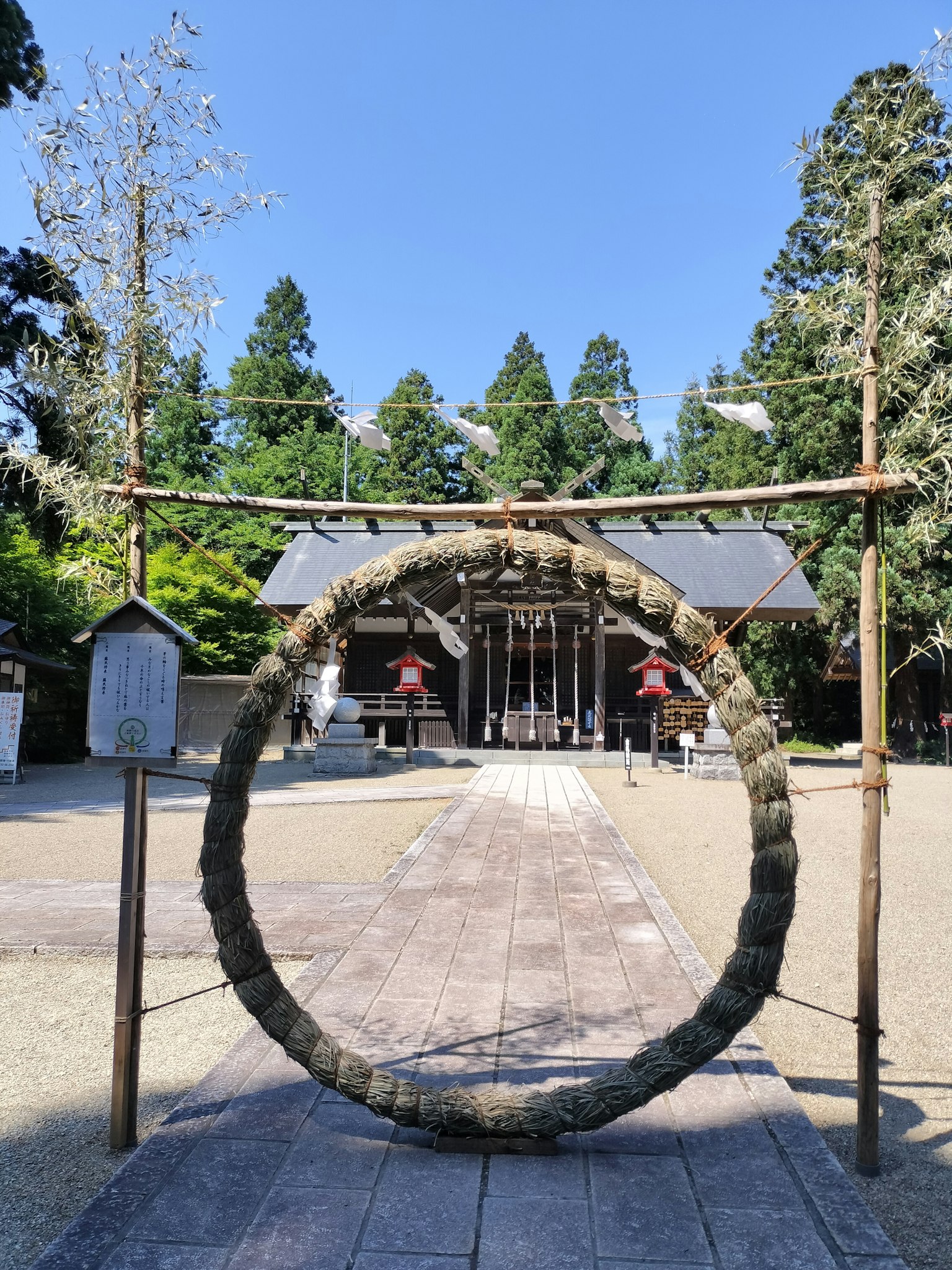 Large decorative ring in front of a shrine with green trees
