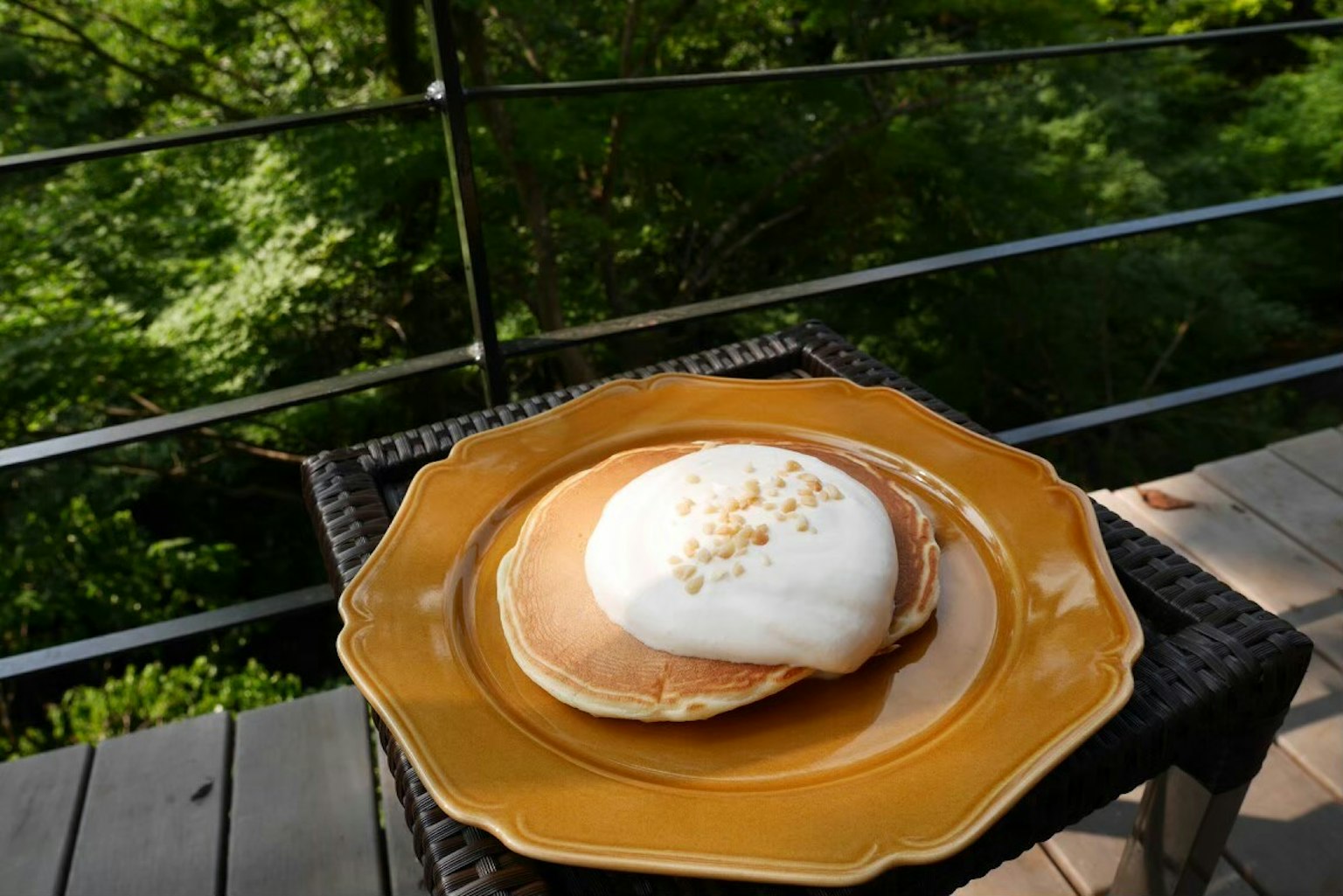 Pancake con panna montata su un piatto giallo all'aperto