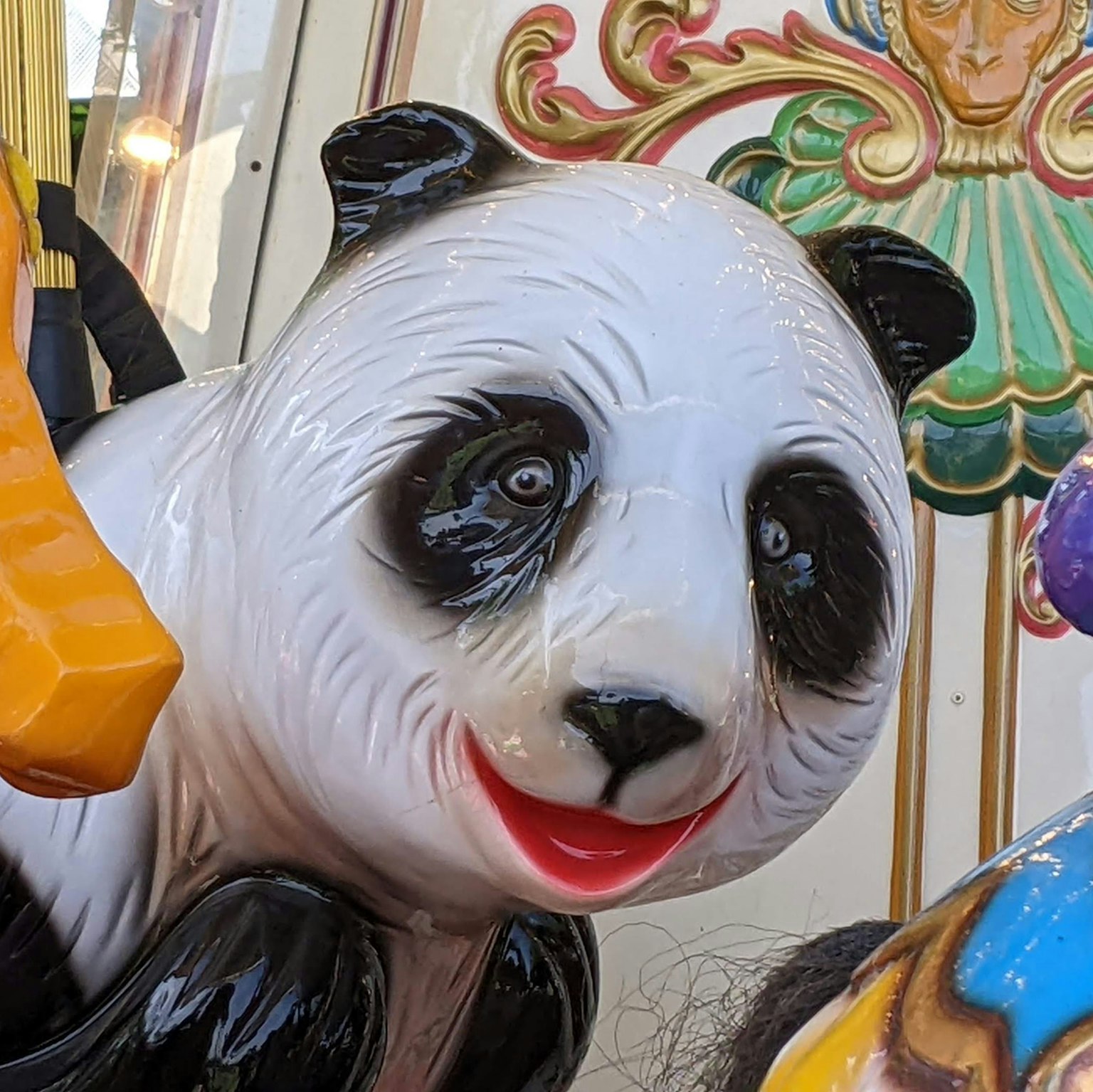 Close-up of a panda ride at an amusement park featuring bright colors and a cheerful expression