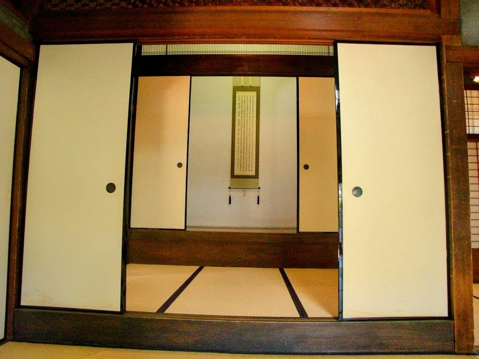 Interno di una stanza giapponese tradizionale con porte scorrevoli e pavimento in tatami