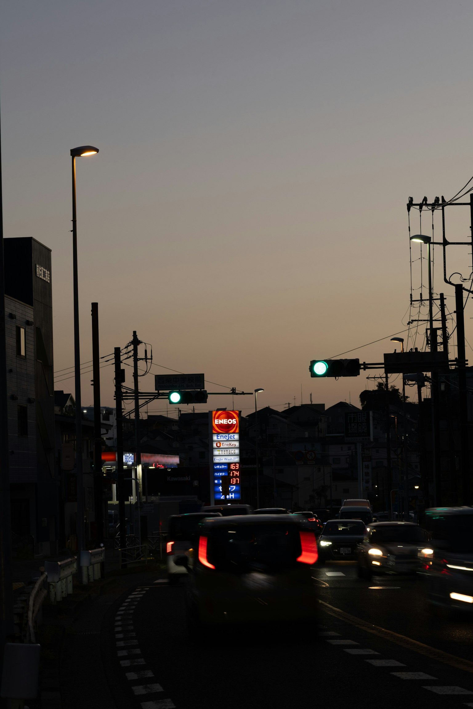 Paysage urbain au crépuscule avec des voitures sur la route et des feux de circulation visibles