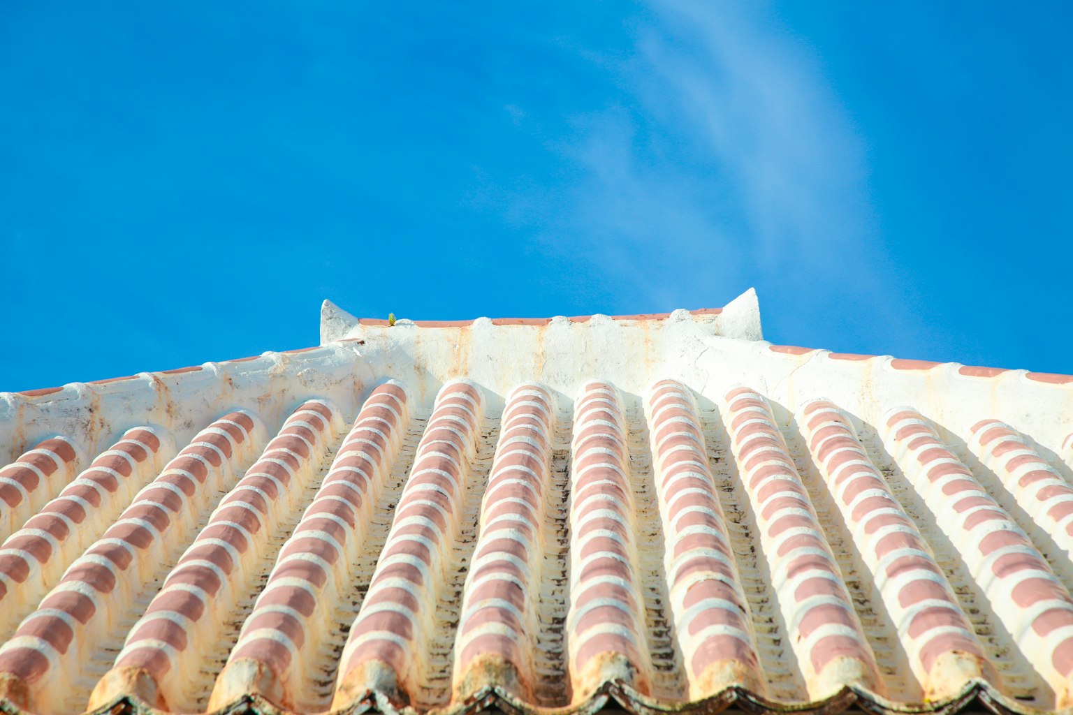 Detailed view of a tiled roof against a blue sky