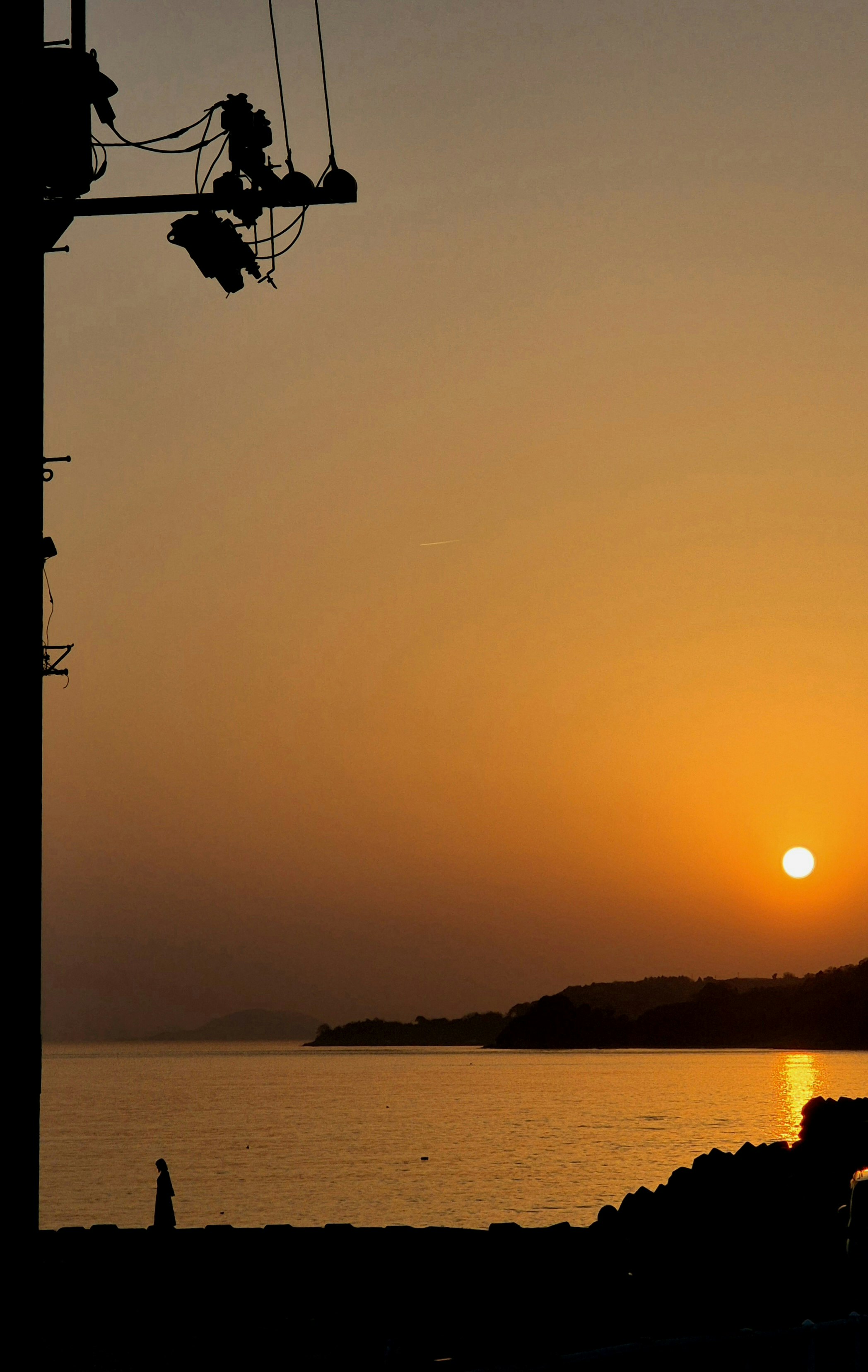 夕日に照らされた海と岸辺のシルエット