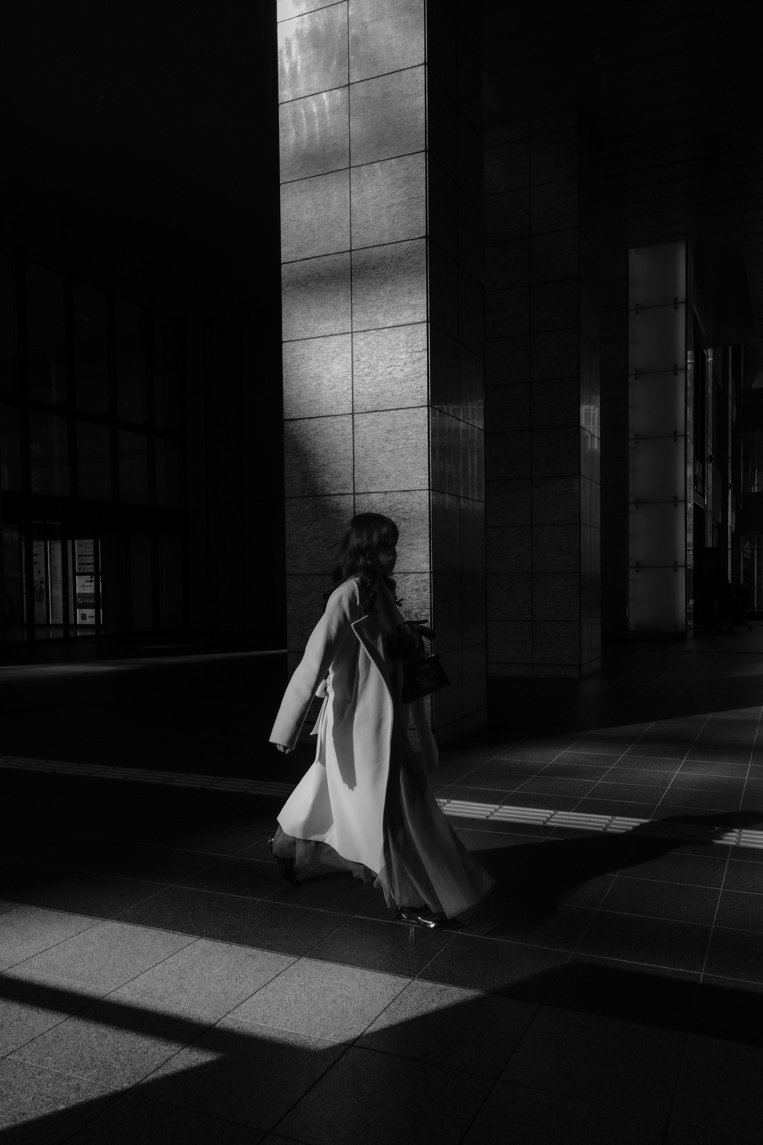 Silhouette of a woman walking in a dark setting striking contrast of light and shadow