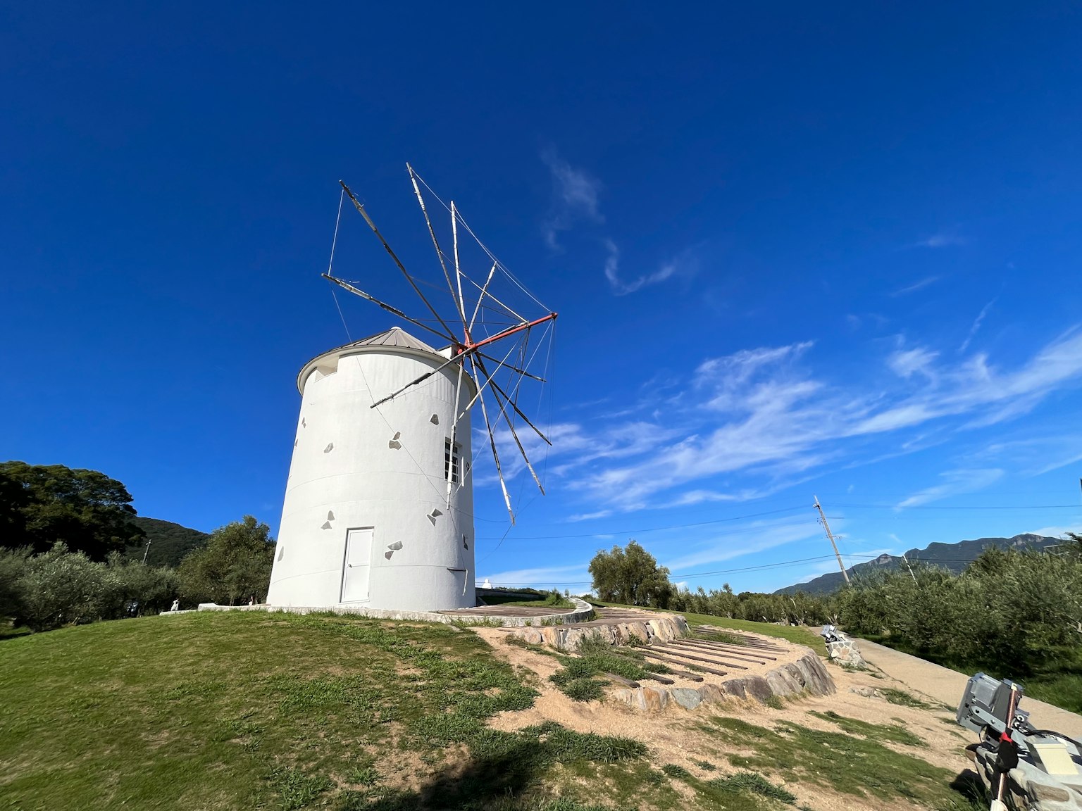 Landscape featuring a windmill under a beautiful blue sky