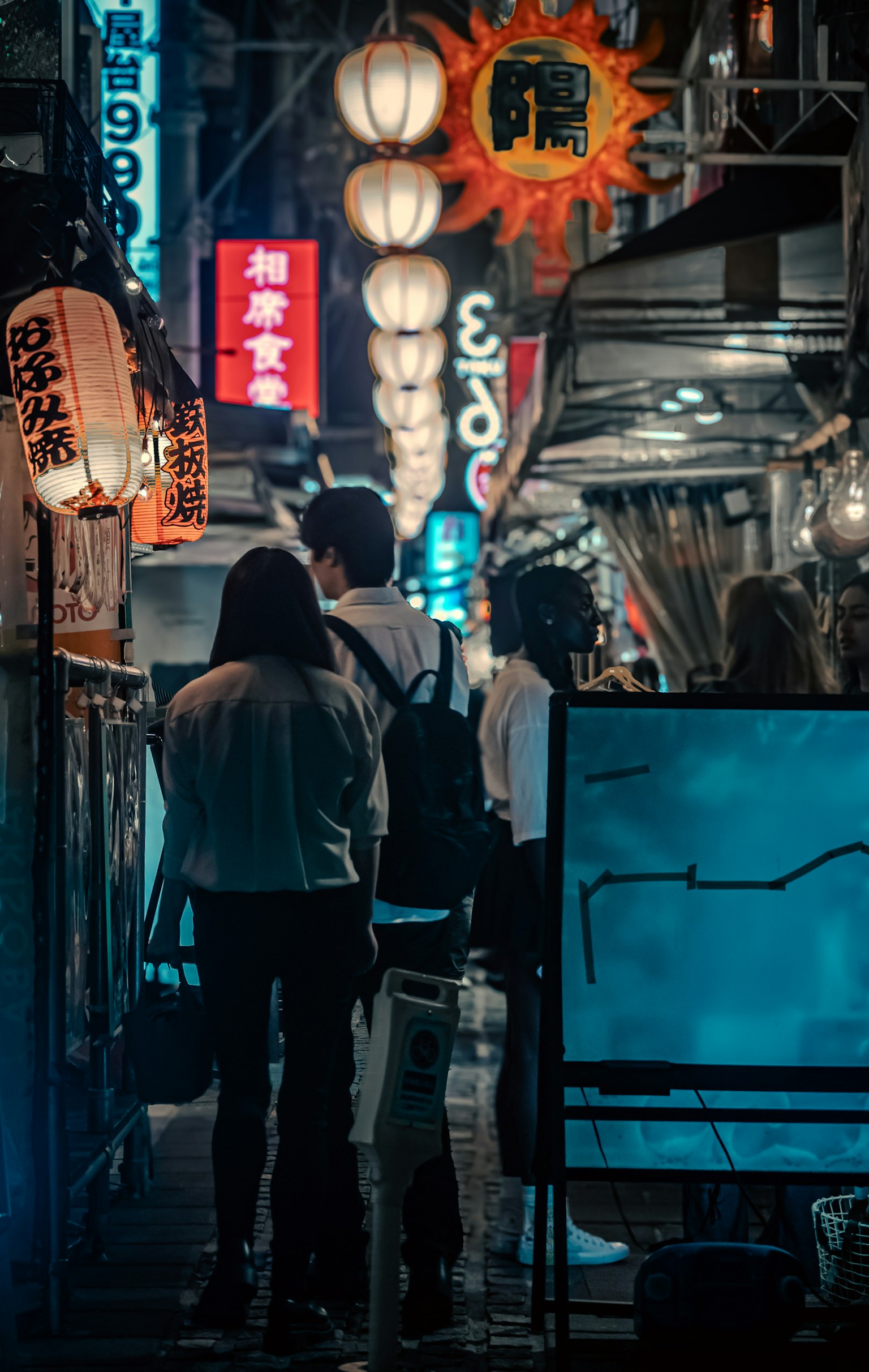 Des gens marchant dans une rue japonaise la nuit avec des lanternes lumineuses