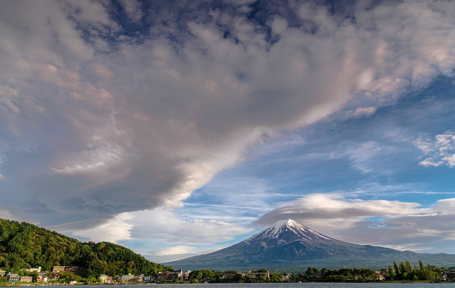 Malersicher Blick auf den Fuji mit blauem Himmel grünen Hügeln und schneebedecktem Gipfel