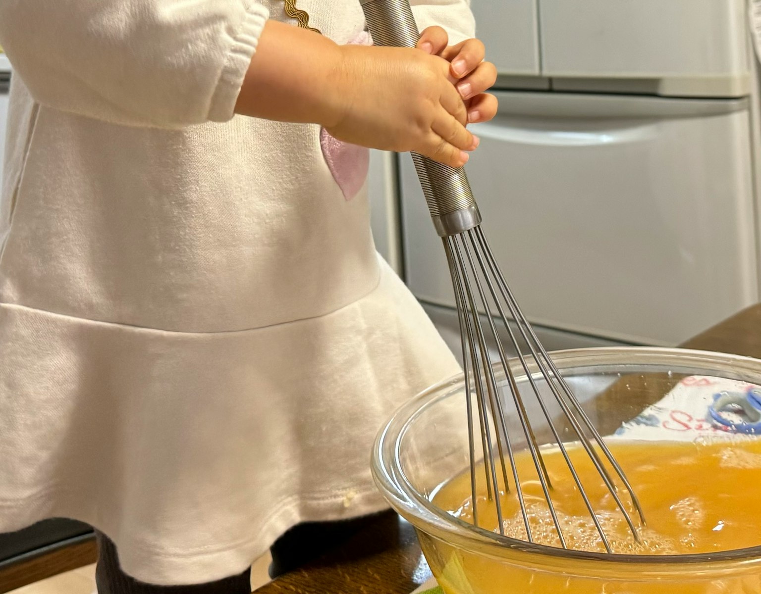 孩子用打蛋器攪拌碗中的液體