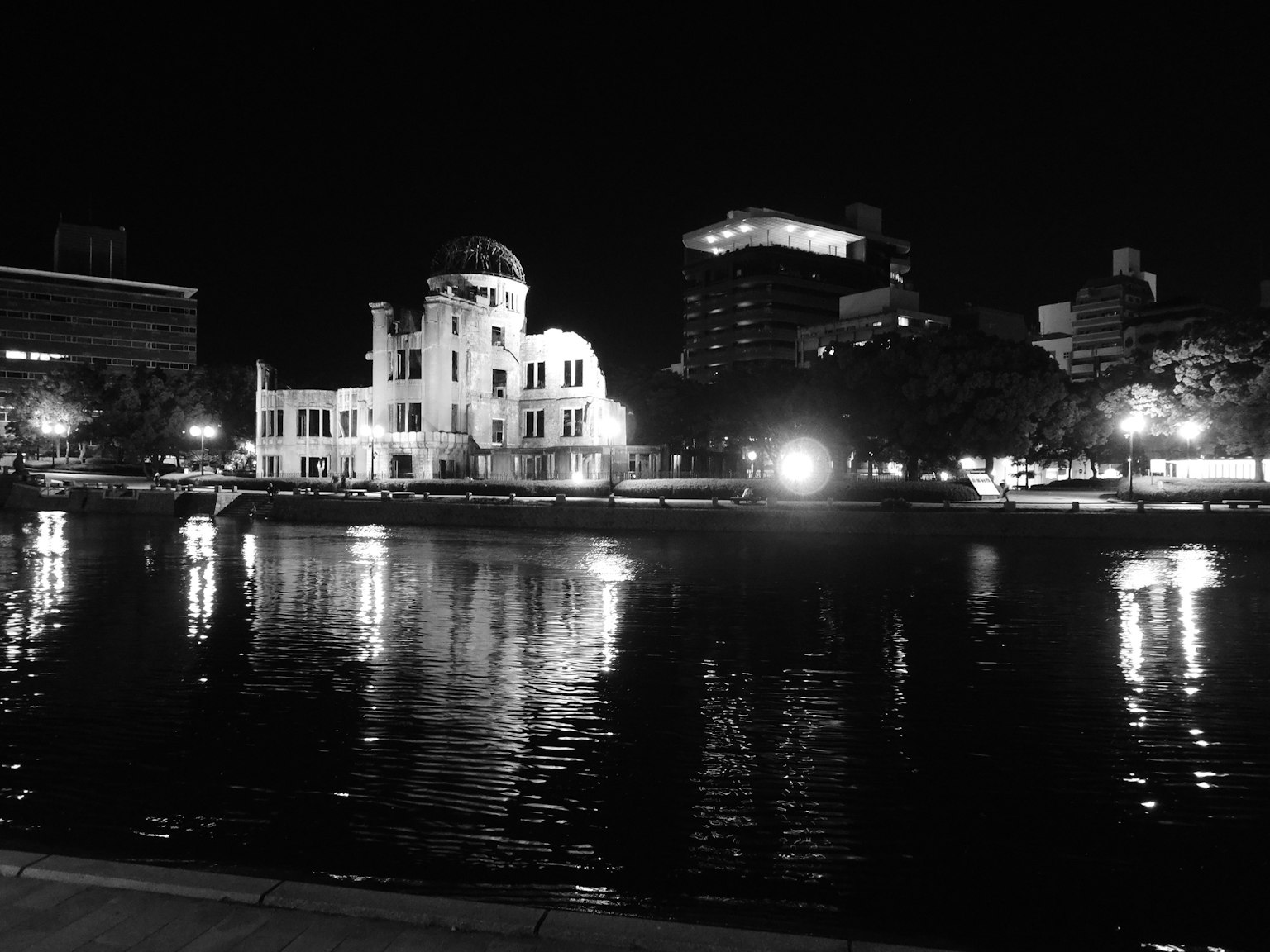 Vista notturna del Museo del Memoriale della Pace di Hiroshima con riflessi sull'acqua
