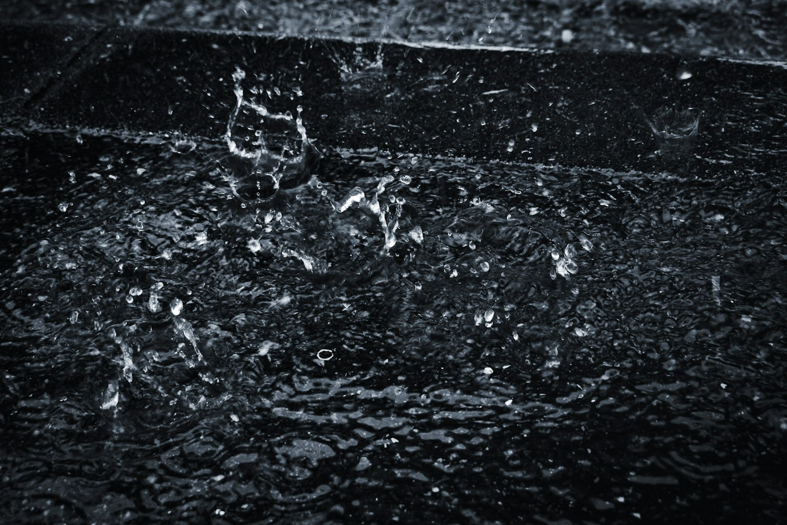 雨滴濺落在黑色表面的特寫