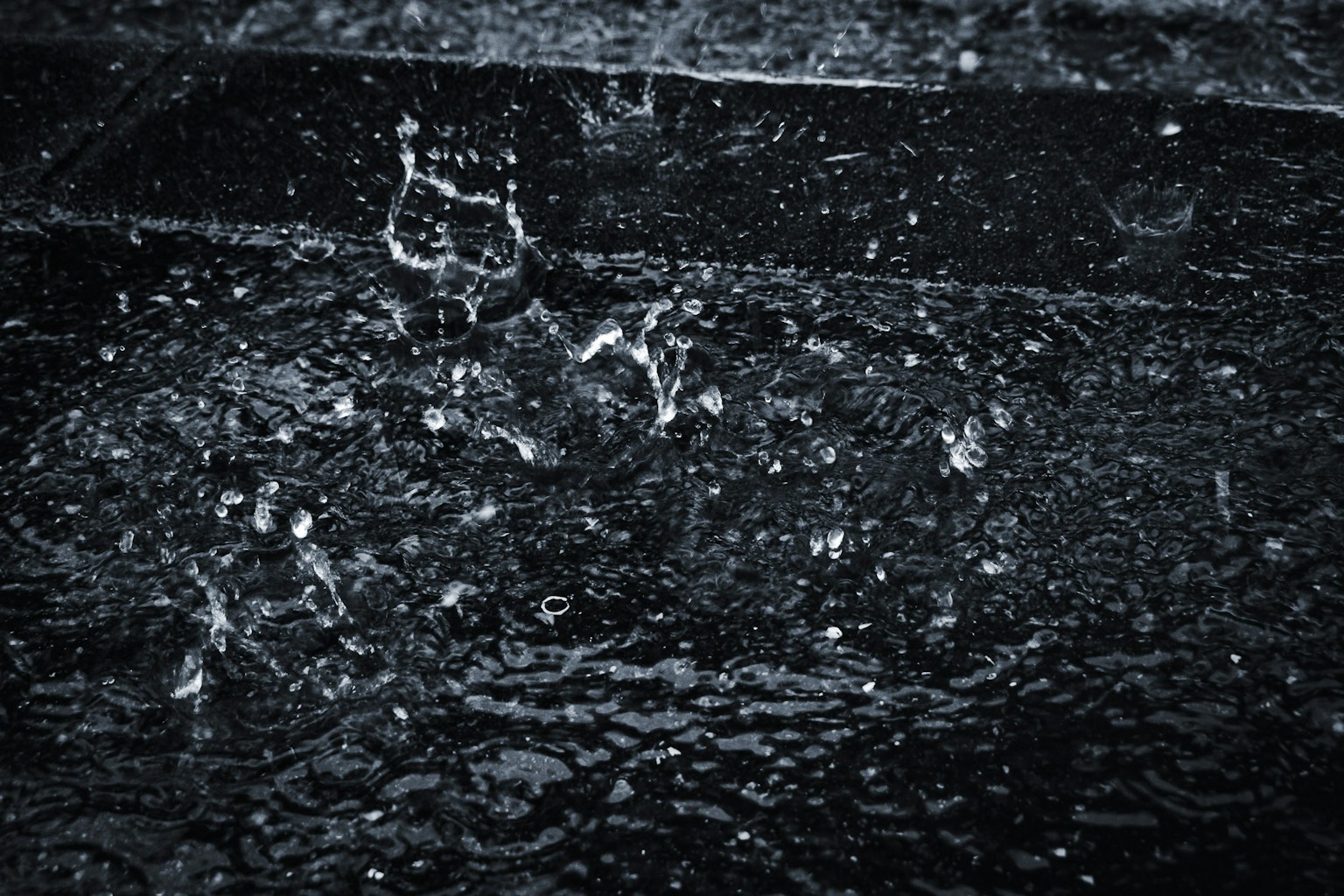 雨滴濺落在黑色表面的特寫