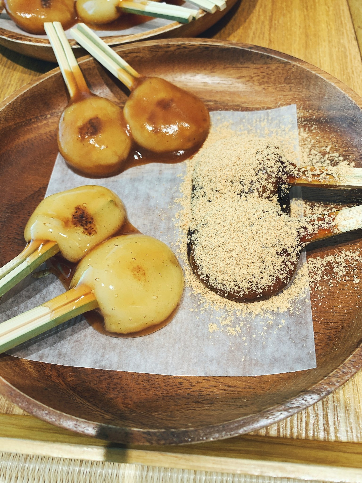 Dango served on a wooden plate with kinako powder