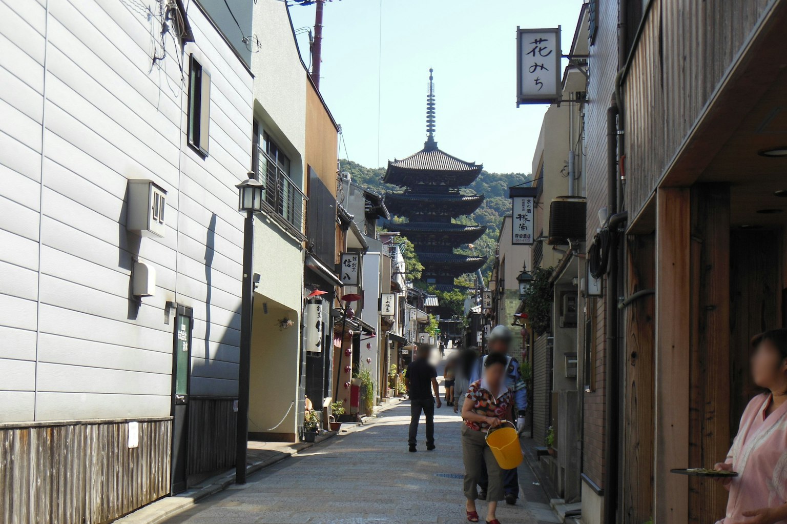 Narrow street lined with people and traditional buildings