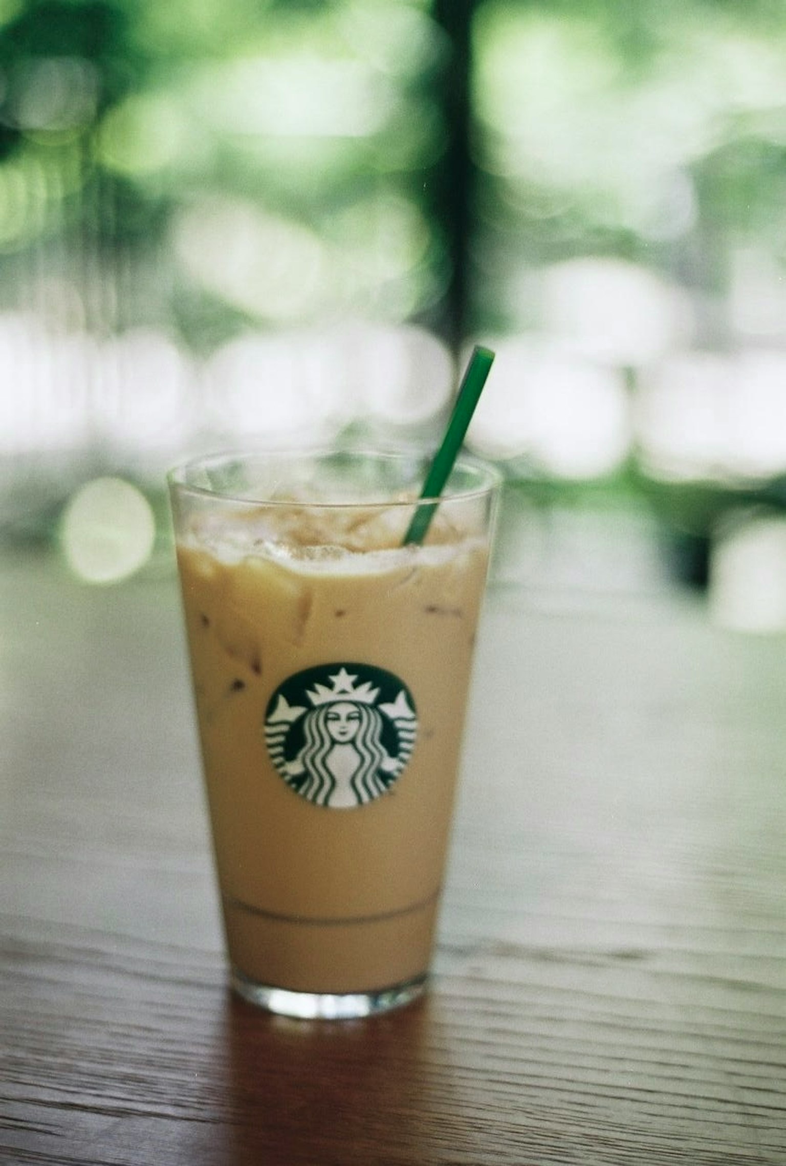 Café glacé Starbucks dans un verre transparent sur une table en bois