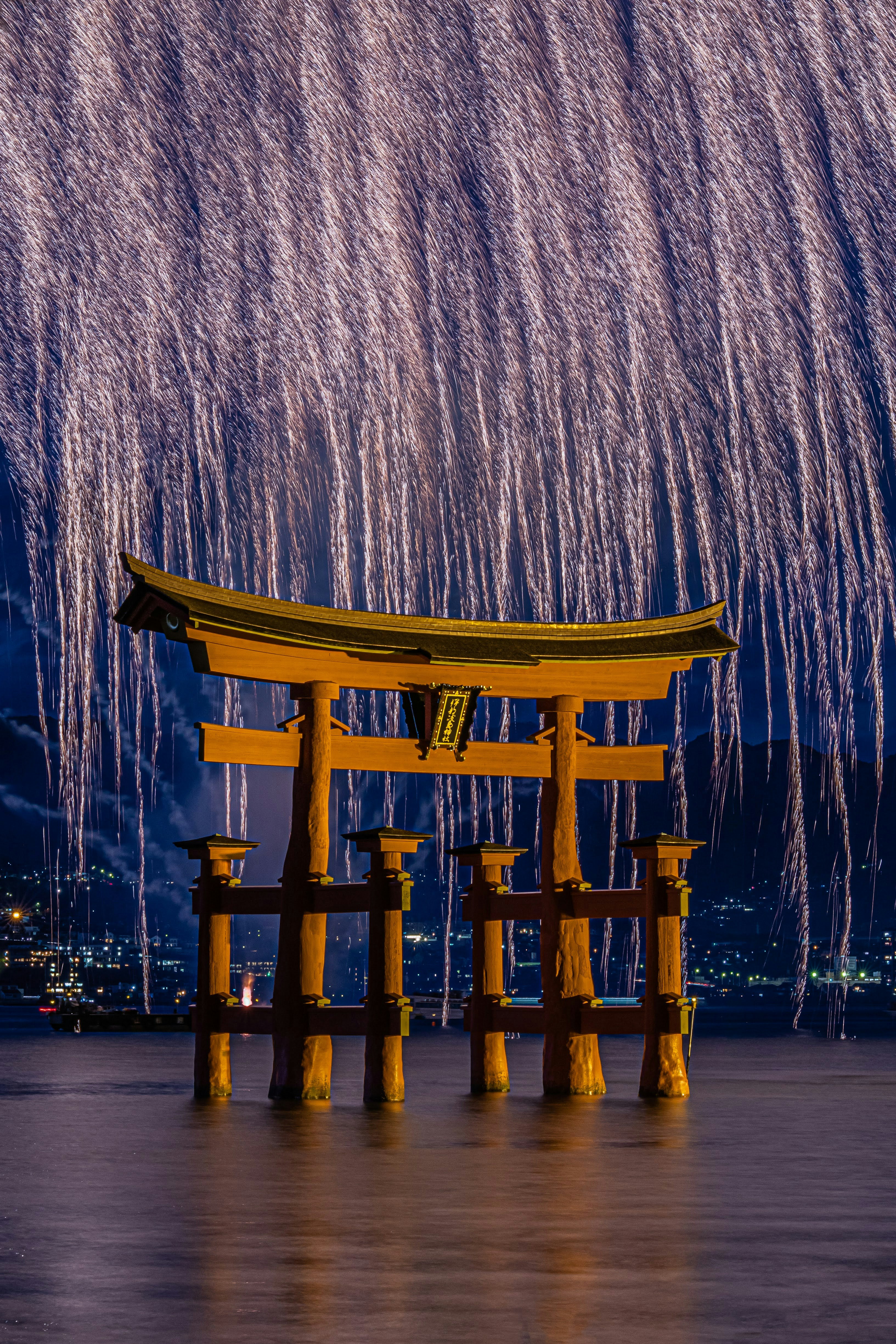 宮島の大鳥居と夜の花火の光