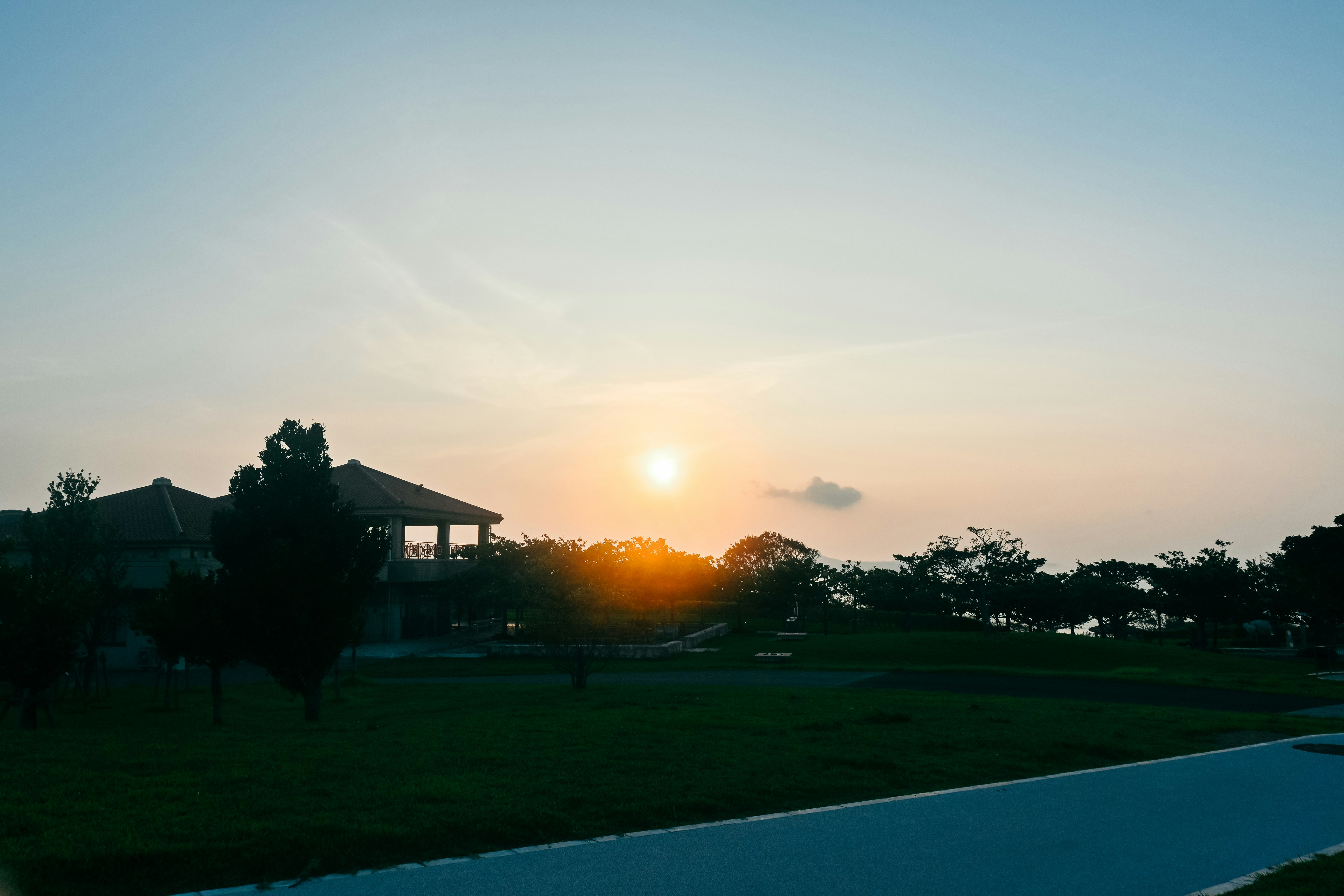 夕阳照亮的草地与远处房屋景色