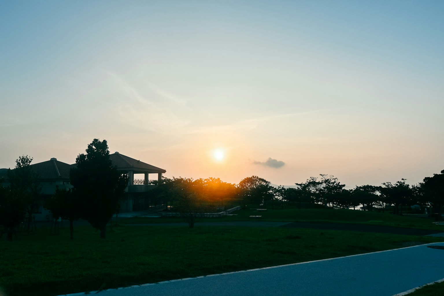 Khung cảnh hoàng hôn với hình bóng ngôi nhà và cây cối trong công viên