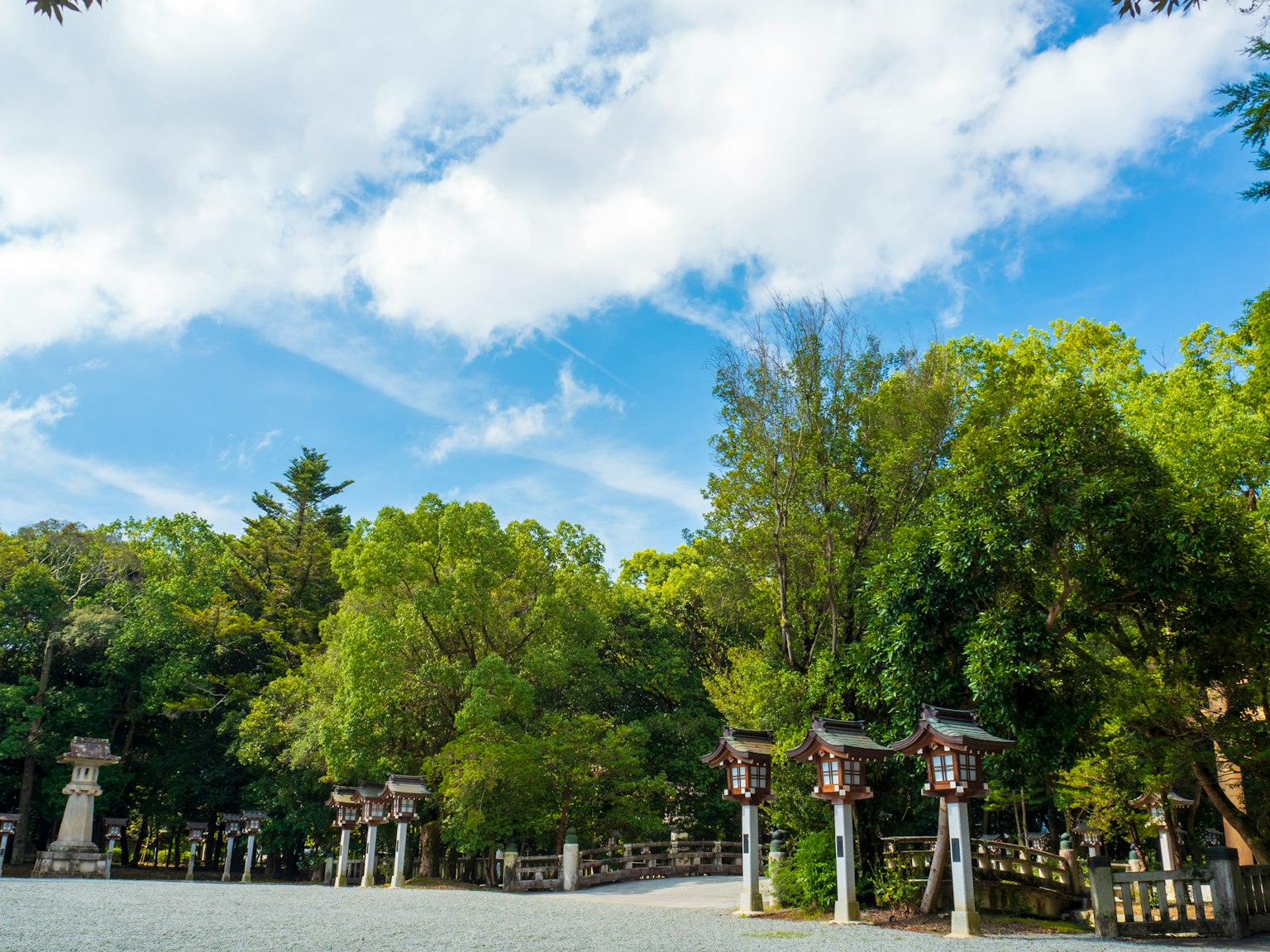 Vista escénica de un parque con torii y vegetación exuberante bajo un cielo azul