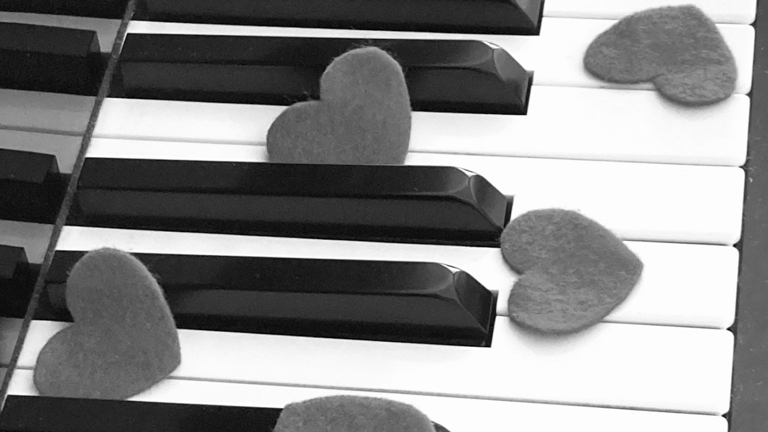 Cuori posati sui tasti del pianoforte che creano un'atmosfera romantica