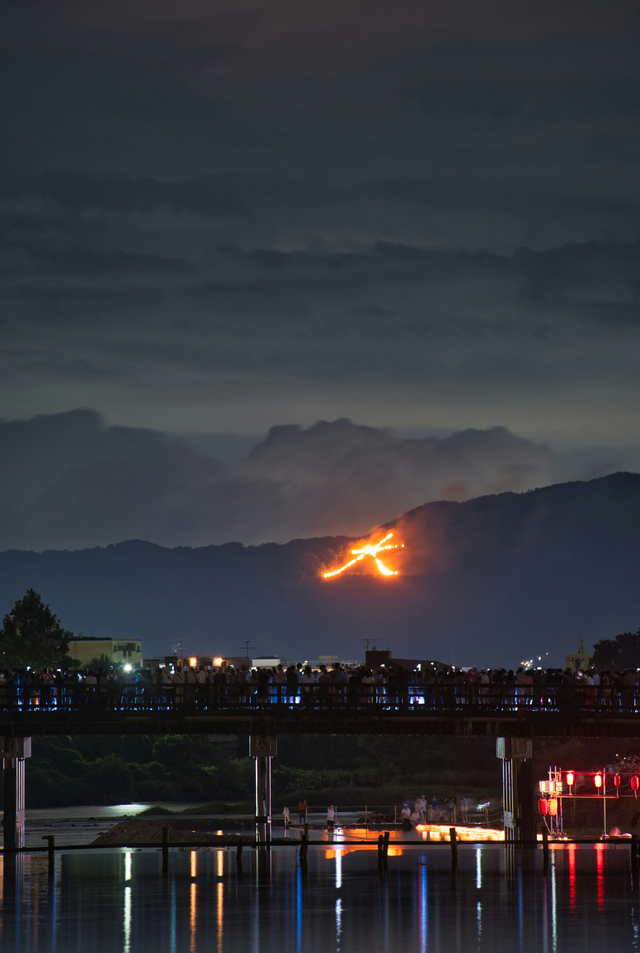 嵐山の渡月橋周辺で灯籠流しと大文字の送り火が見える夜景