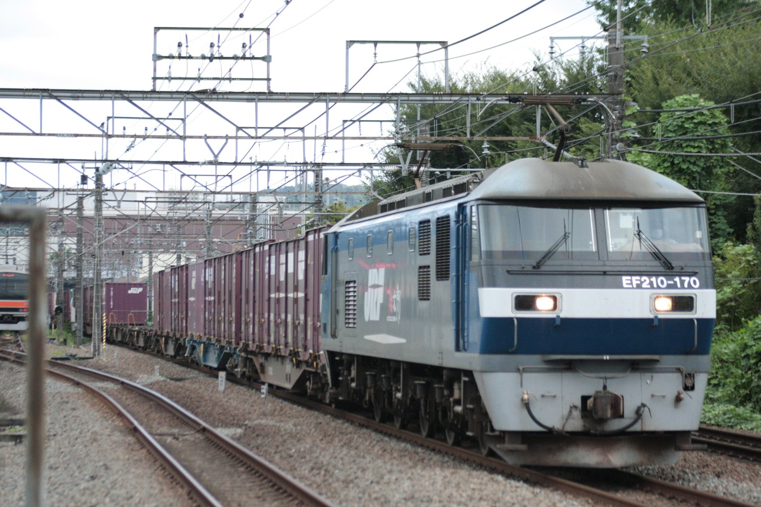 Tren de carga azul que circula por las vías