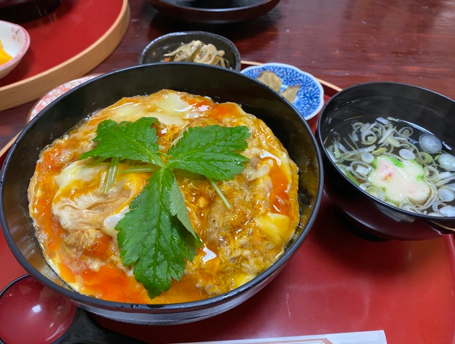 米饭碗上覆盖着番茄酱和鸡蛋，装饰着一片大叶子