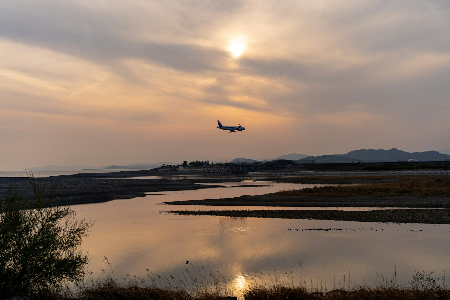 Un paesaggio bellissimo con un aereo che vola contro il tramonto
