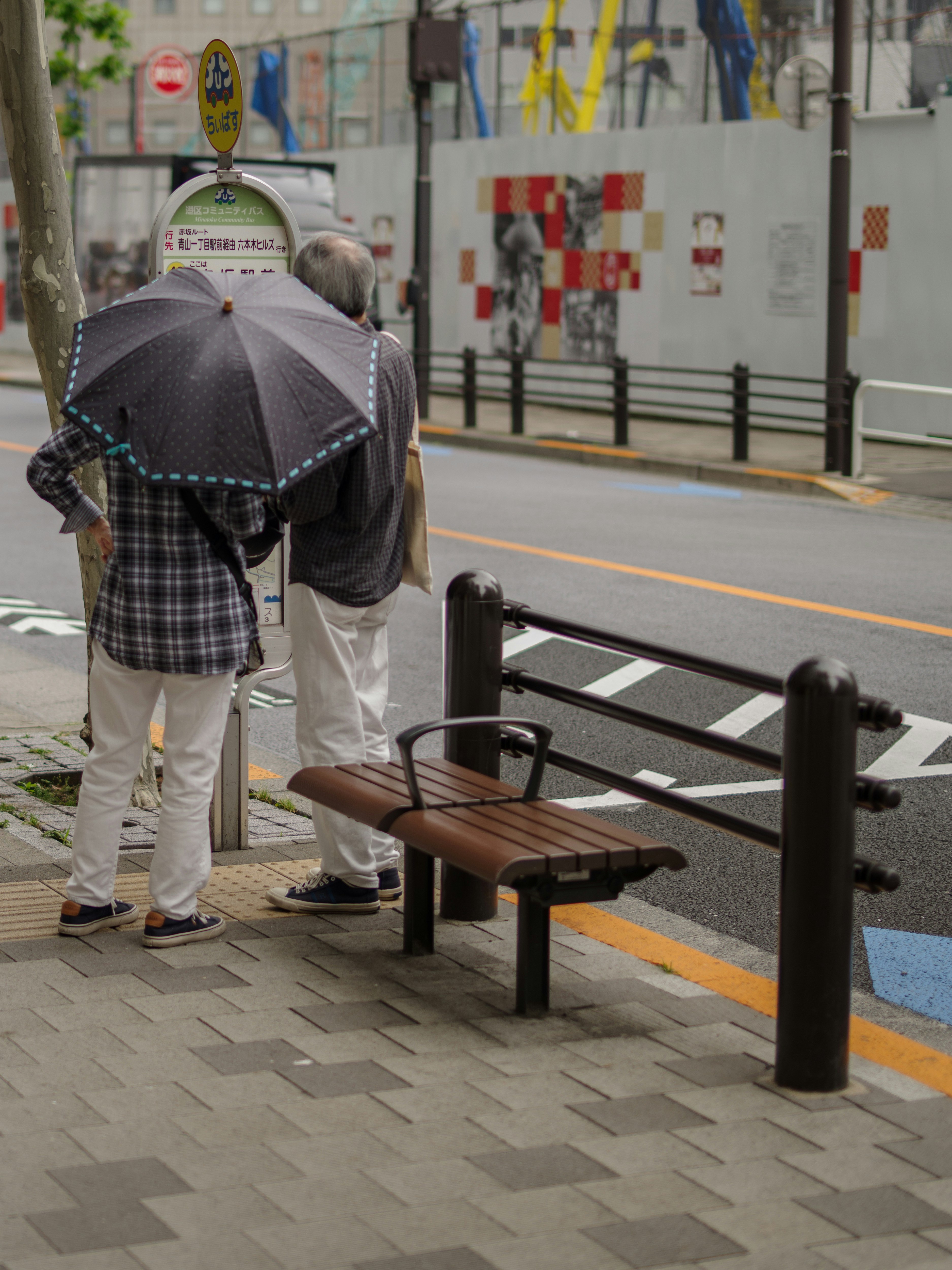 地域を走るコミュニティバスの乗り場のベンチと傘