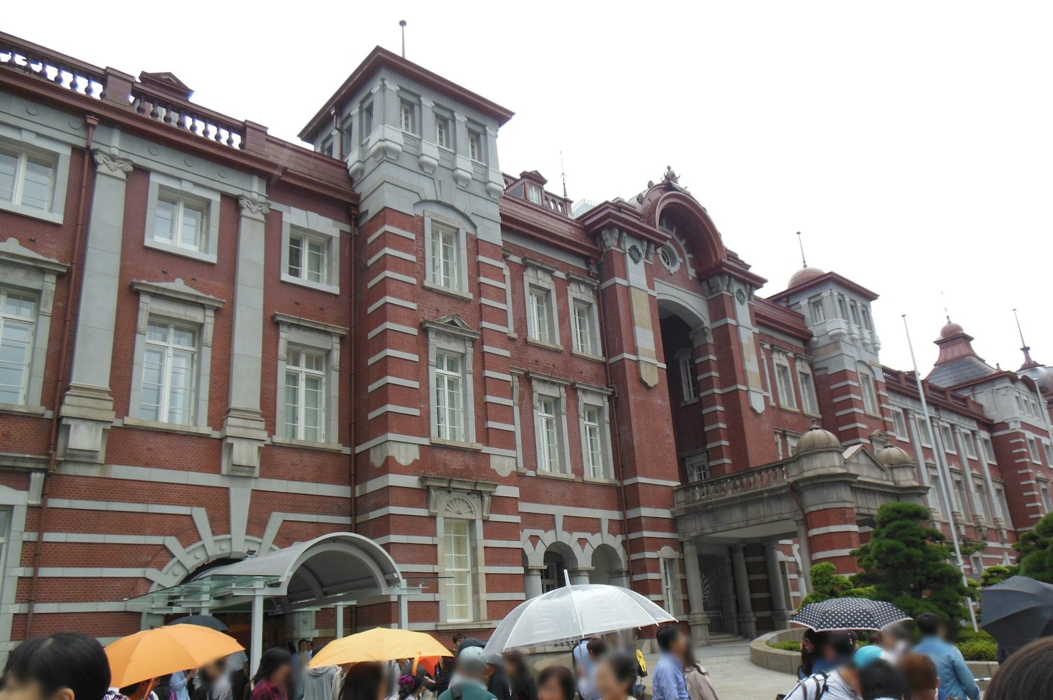 紅磚建築和拿著雨傘的遊客