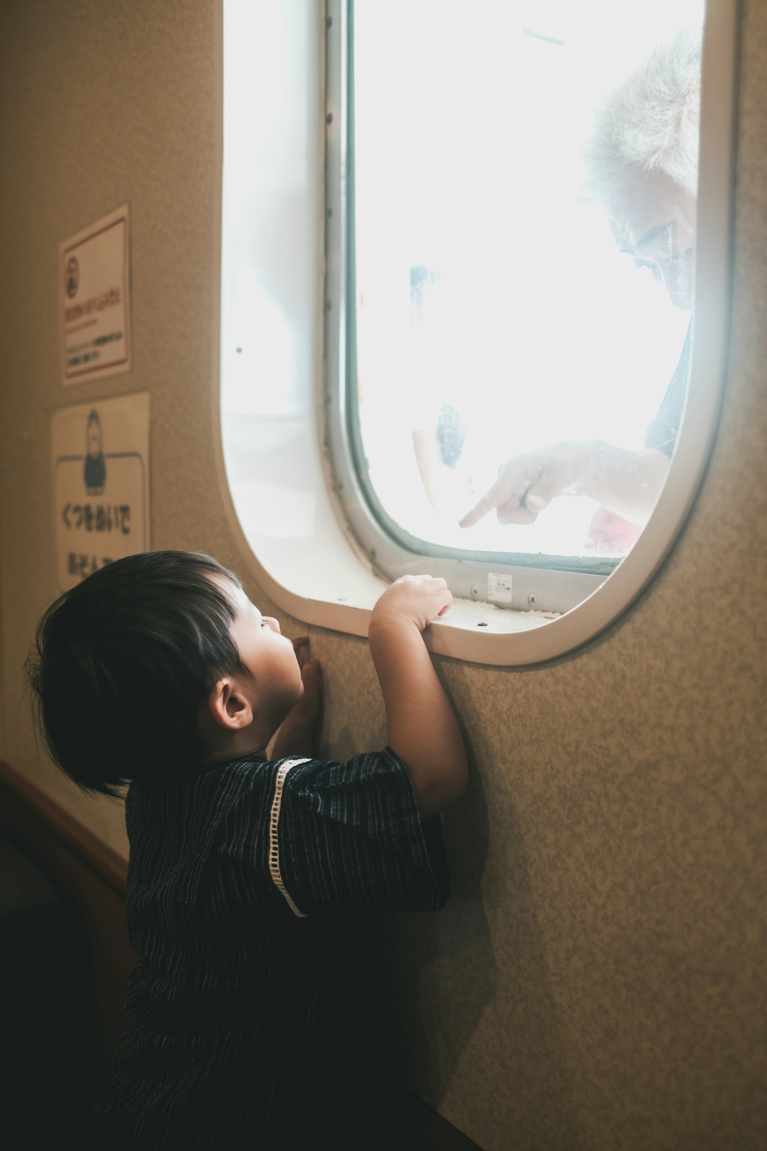 窓の外を見つめる子供の姿 窓の形が特徴的