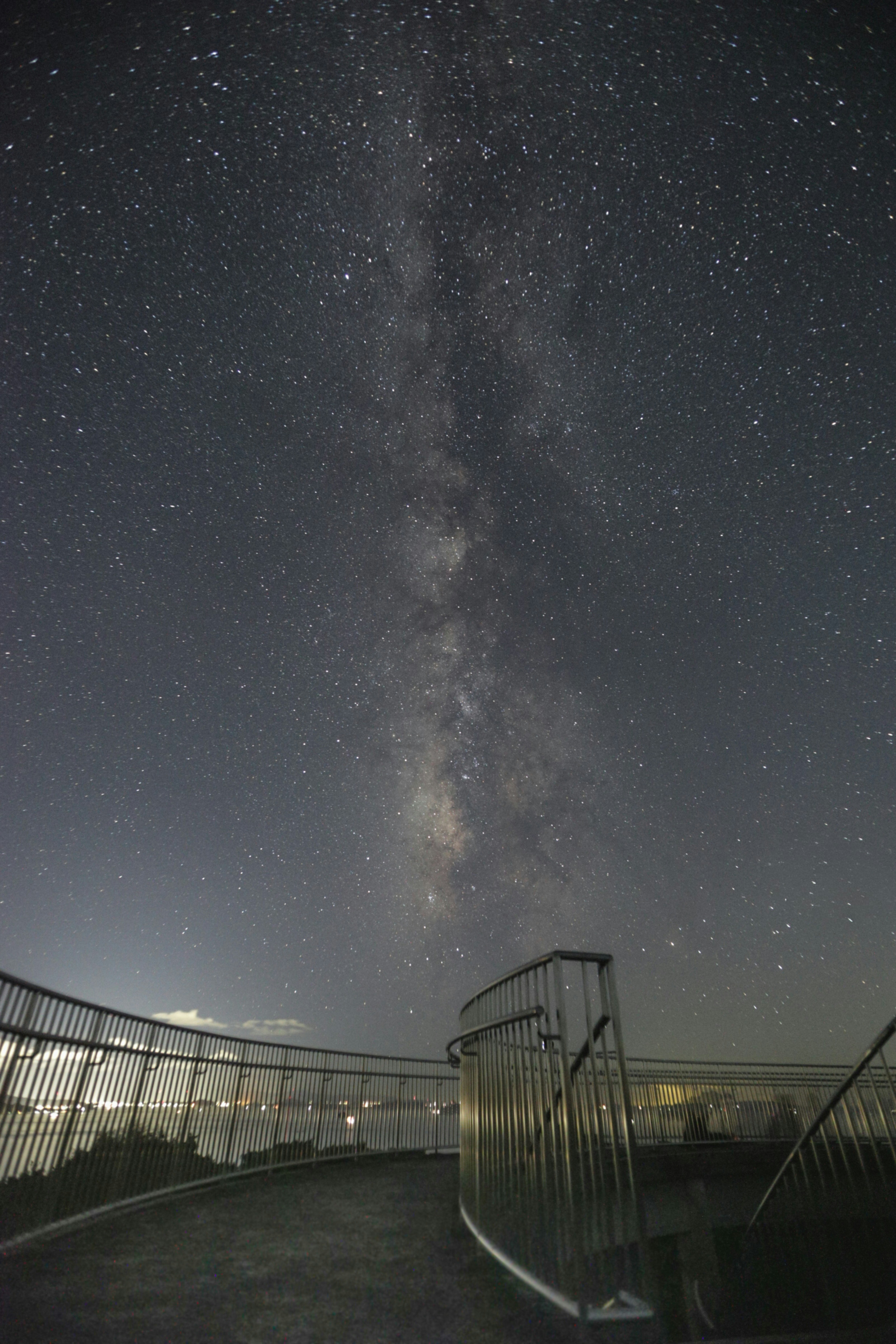 夜空に広がる天の川と星が見える展望デッキ