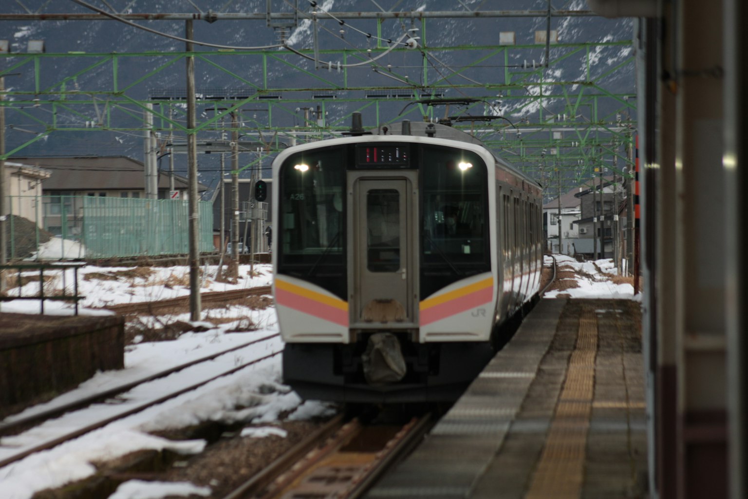 Tren detenido en vías nevadas con montañas al fondo