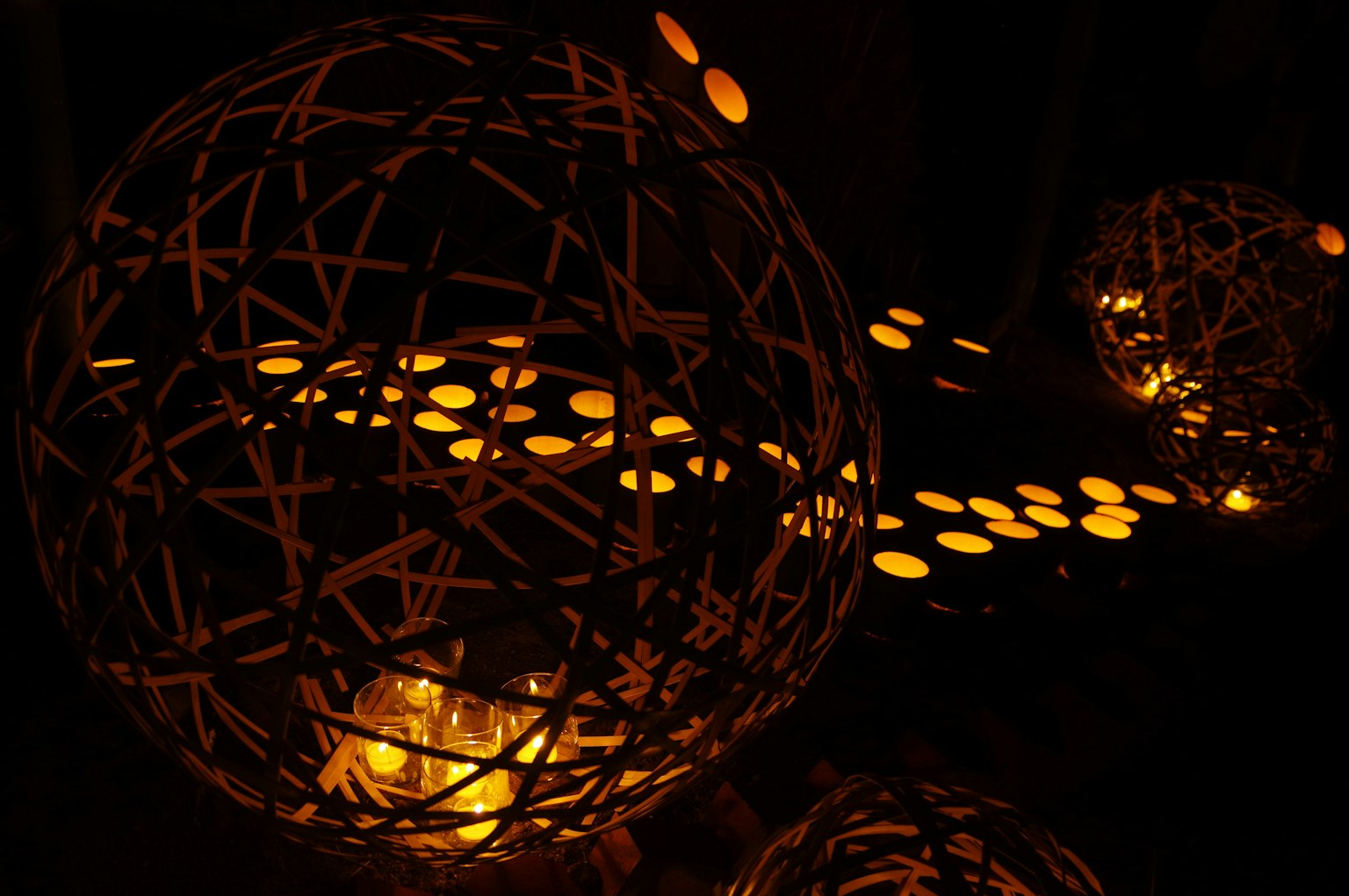 Lumières sphériques décoratives émettant une lueur chaleureuse sur fond sombre
