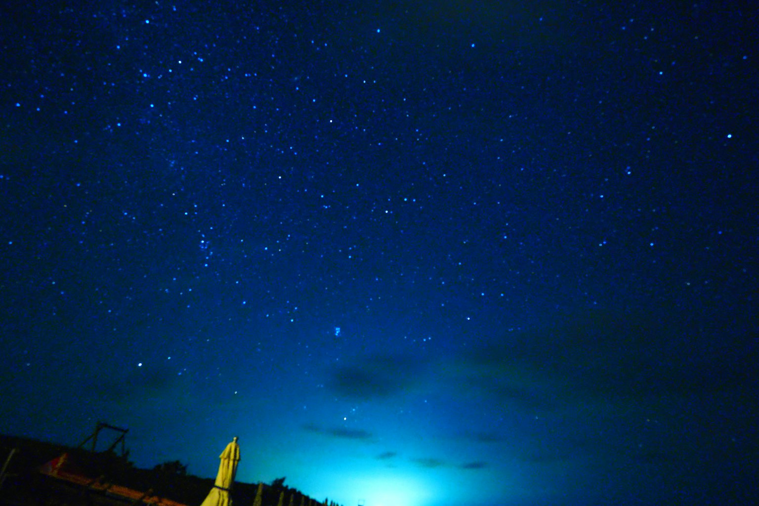 Starry night sky with blue light and clouds