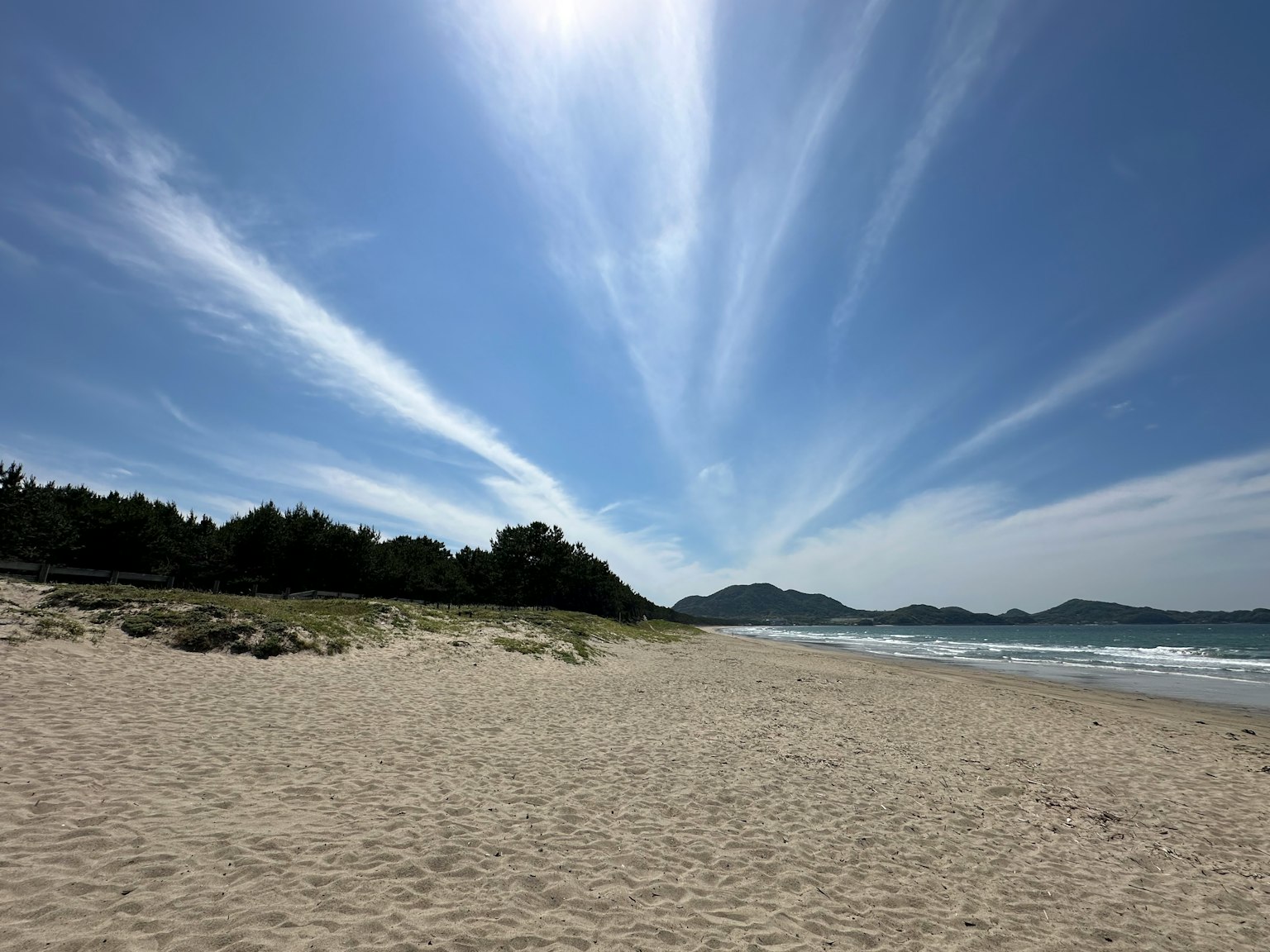 Paysage de plage avec ciel bleu et nuages fins rivage de sable et océan visible