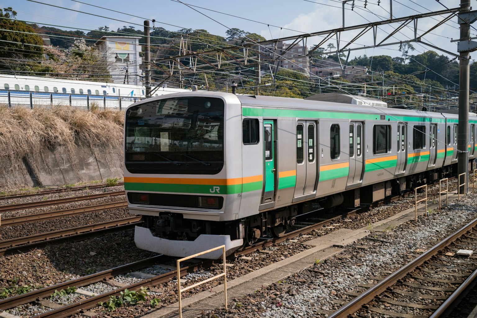 Ein japanischer Zug mit grünen und gelben Streifen, der auf den Gleisen parkt