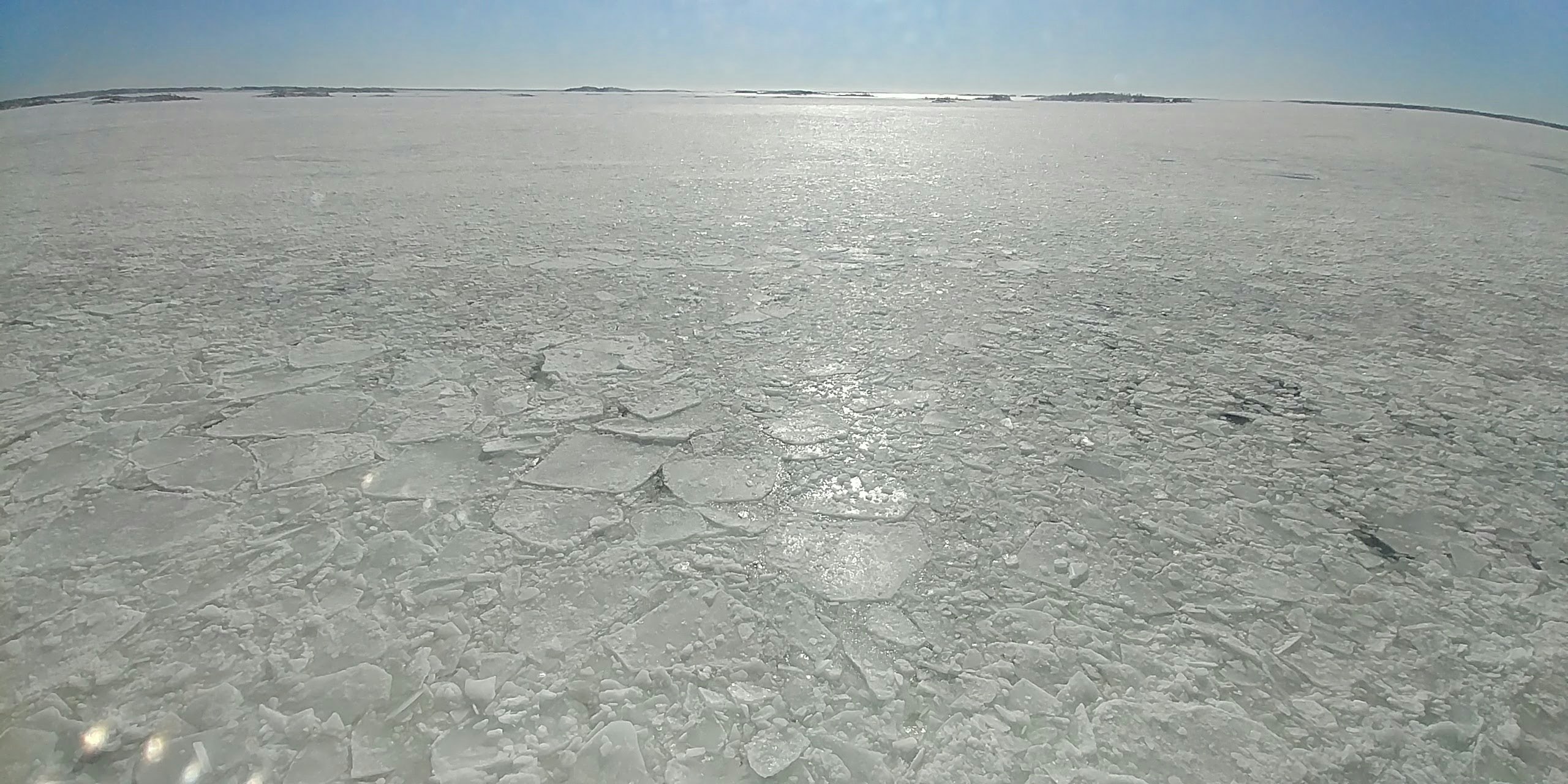広い塩原の上に広がる水面と遠景の地平線
