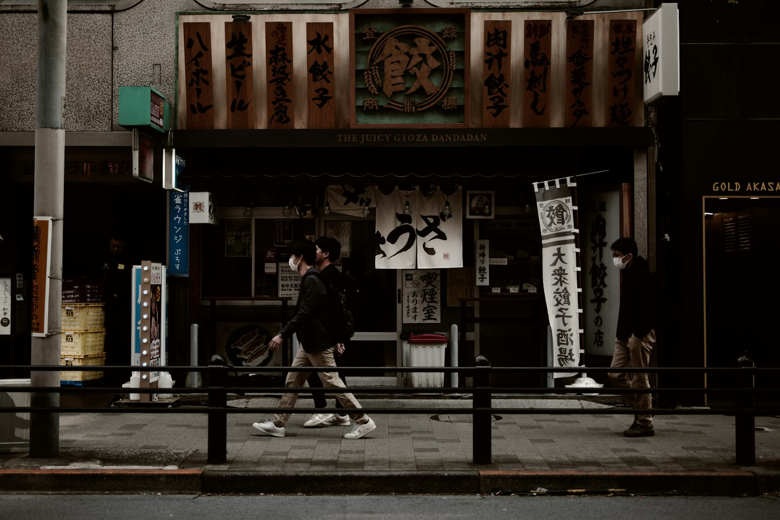 Restaurant japonais traditionnel dans une rue sombre avec des piétons