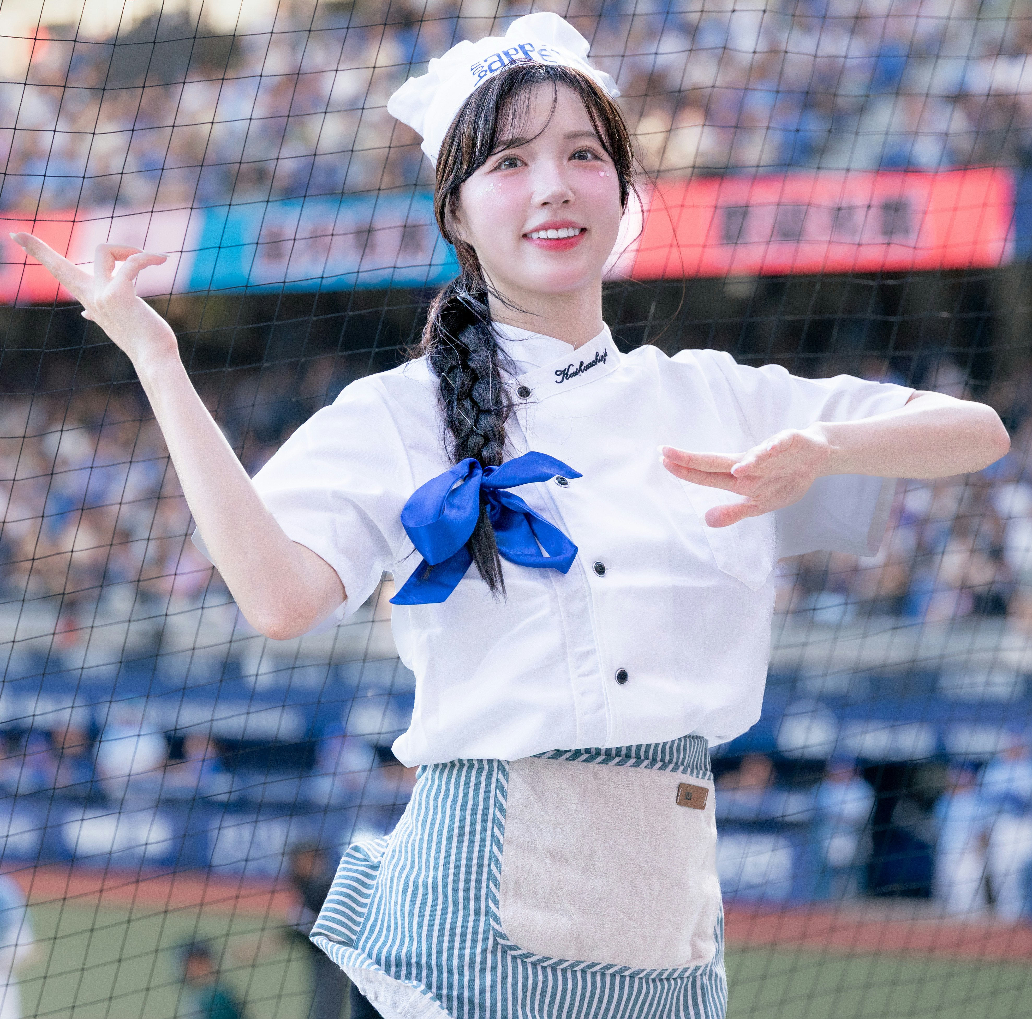 スタジアム前で笑顔の制服姿の女性