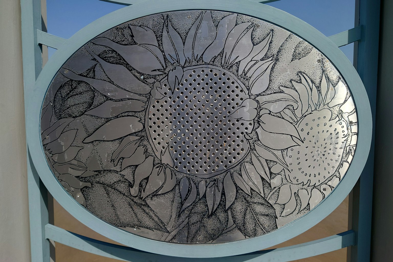 Pannello ovale in metallo con girasoli e foglie incisi