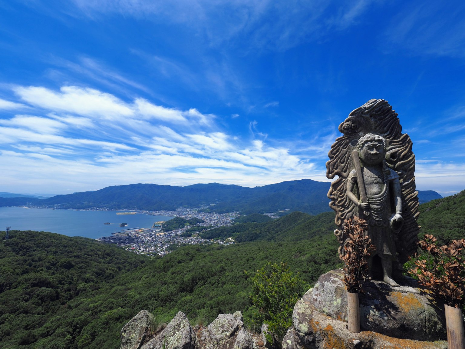 Escultura de piedra con vista costera y cielo azul