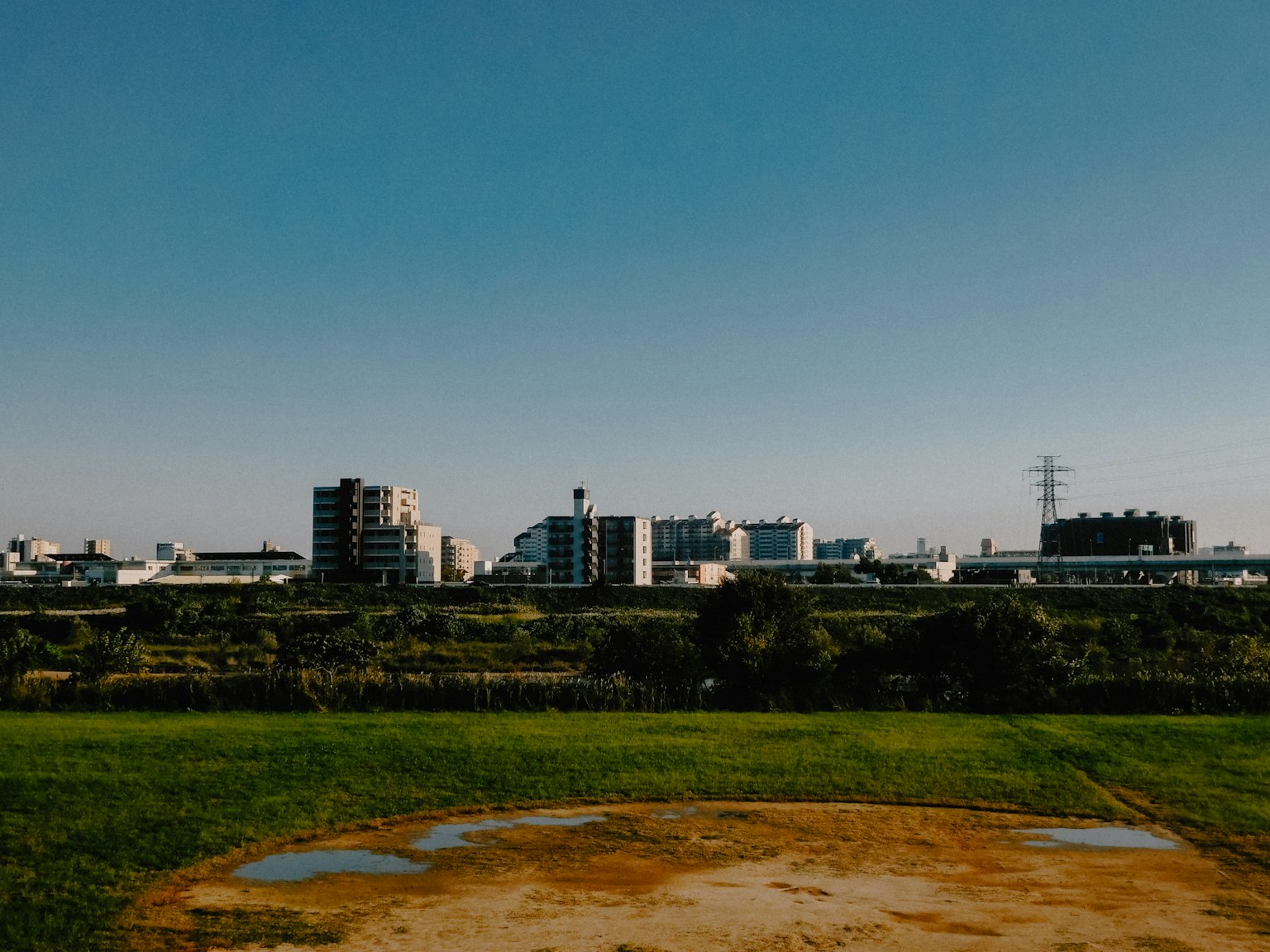 Orizzonte urbano sotto un cielo azzurro chiaro con erba verde in primo piano