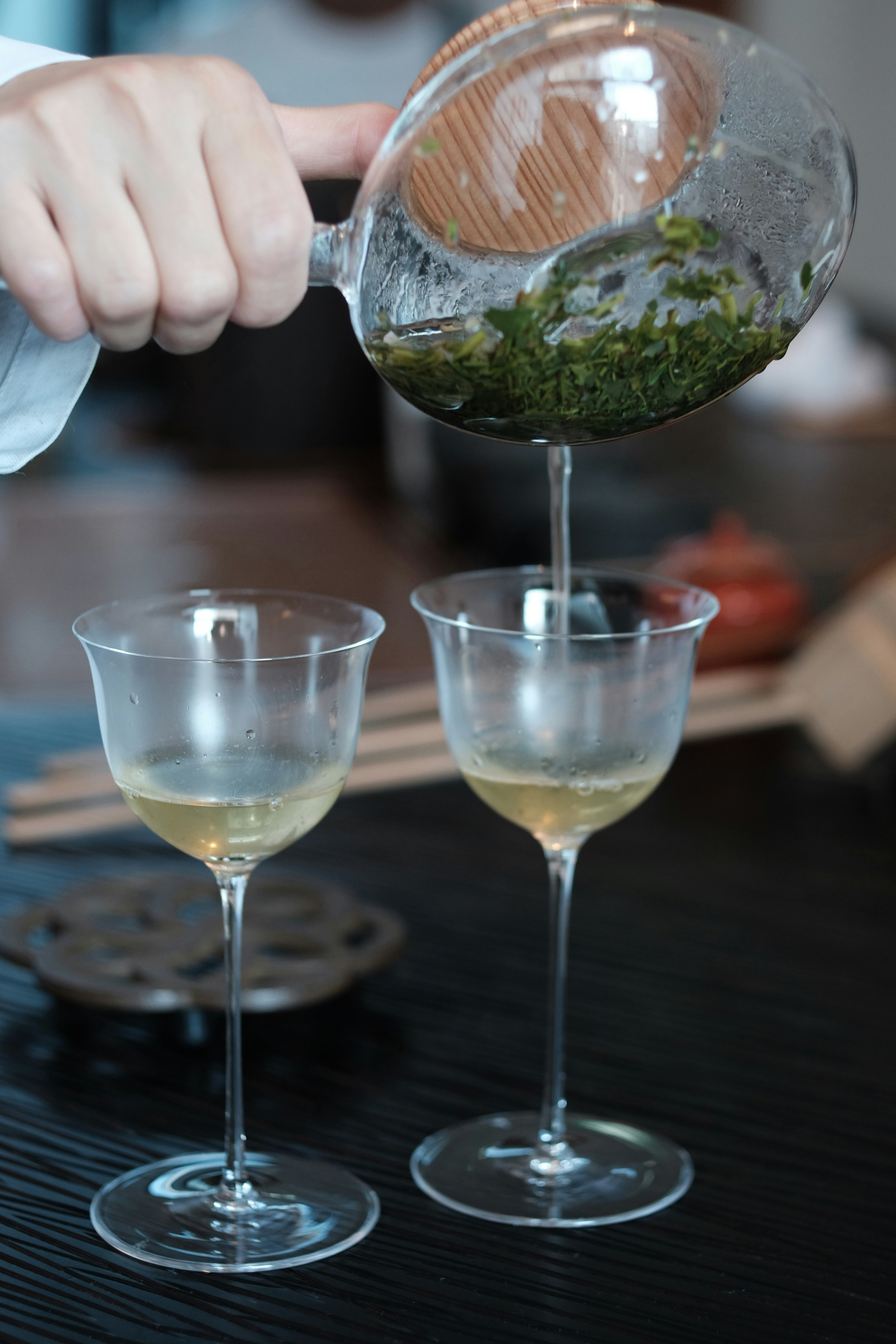 ガラスのティーポットから注がれるお茶とグラスのあるテーブル