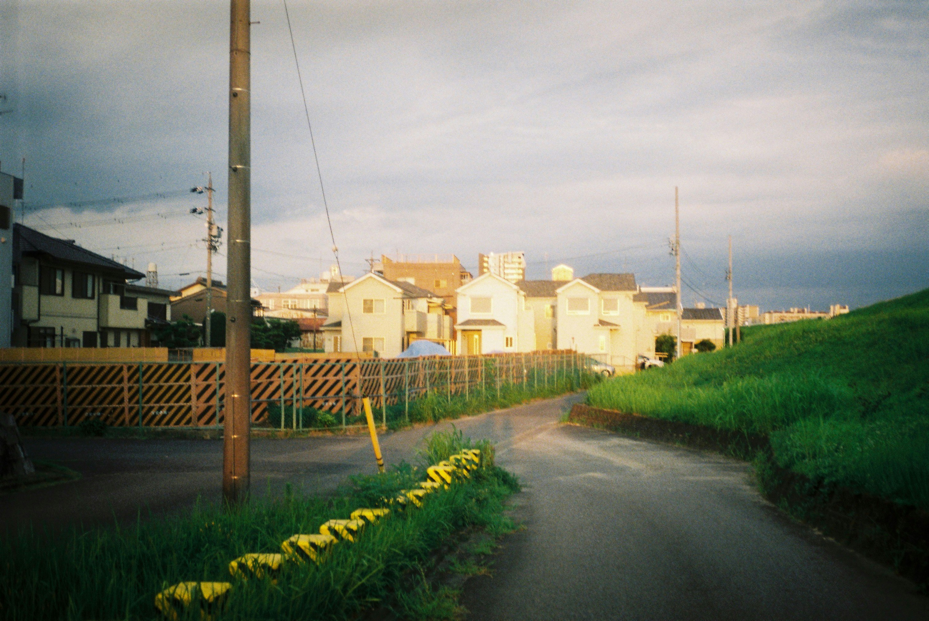 郊外の住宅街を走る細い道と電柱